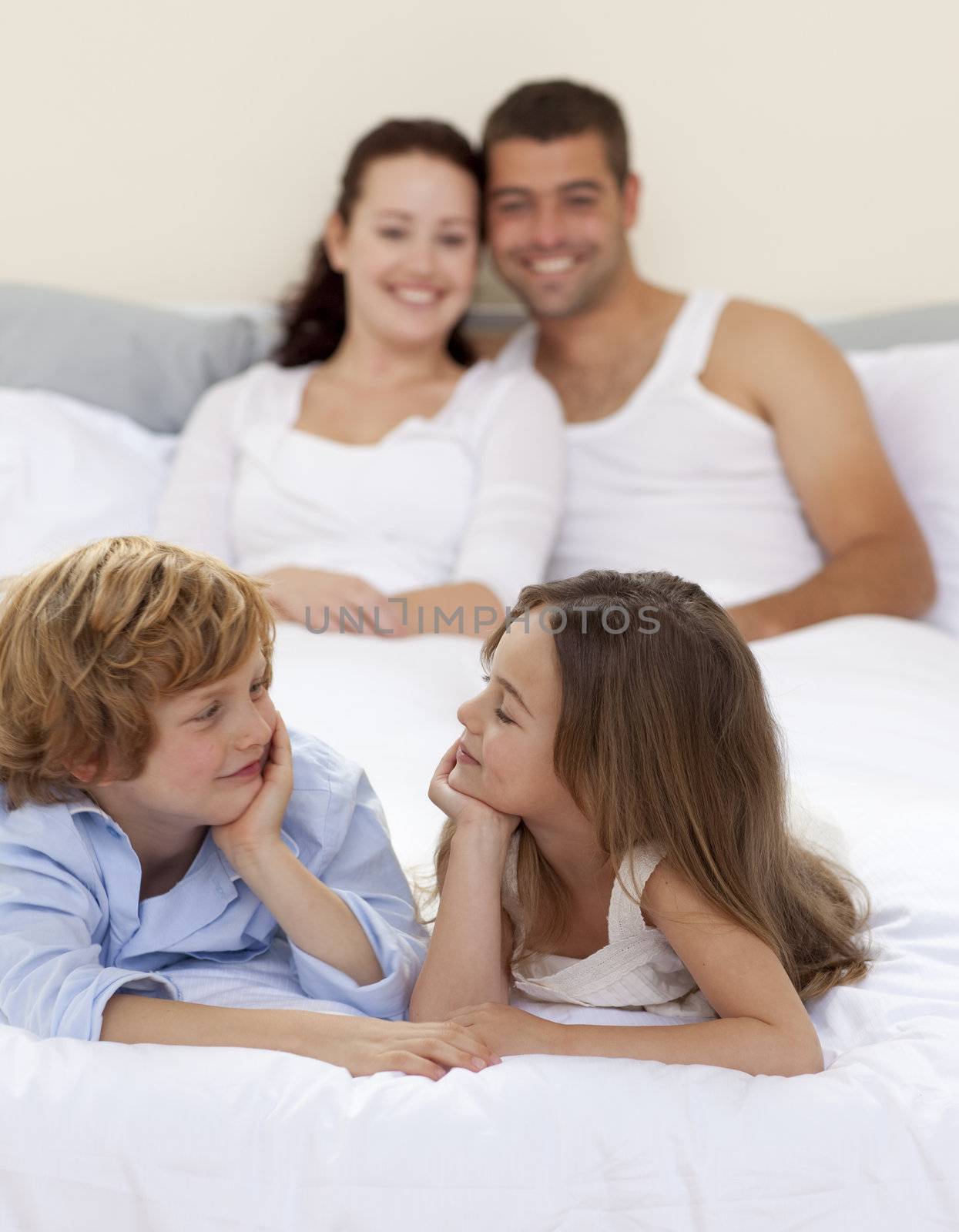 Cute brother and sister in bed with her parents