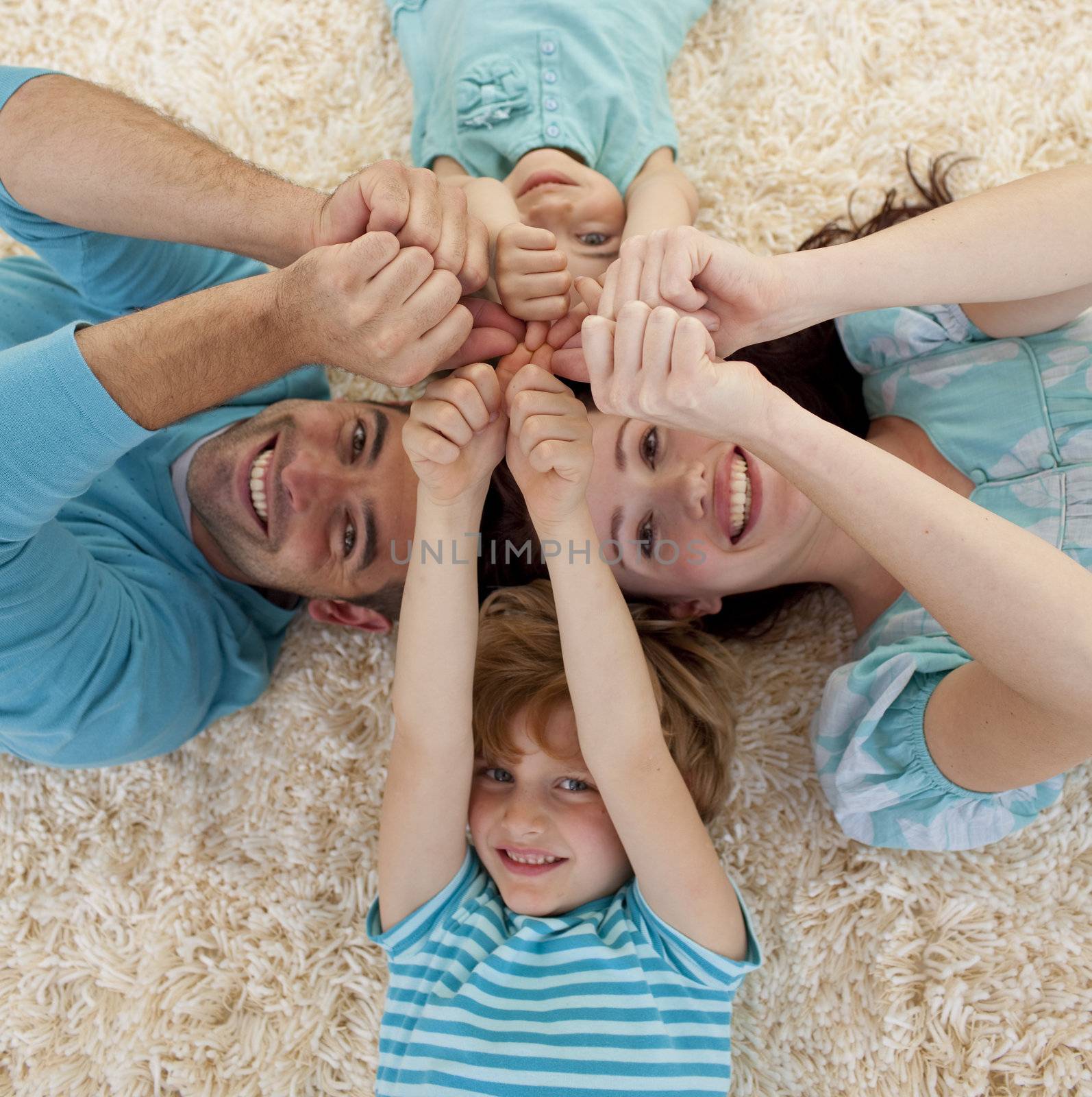 High angle of family on floor with heads and hands together by Wavebreakmedia