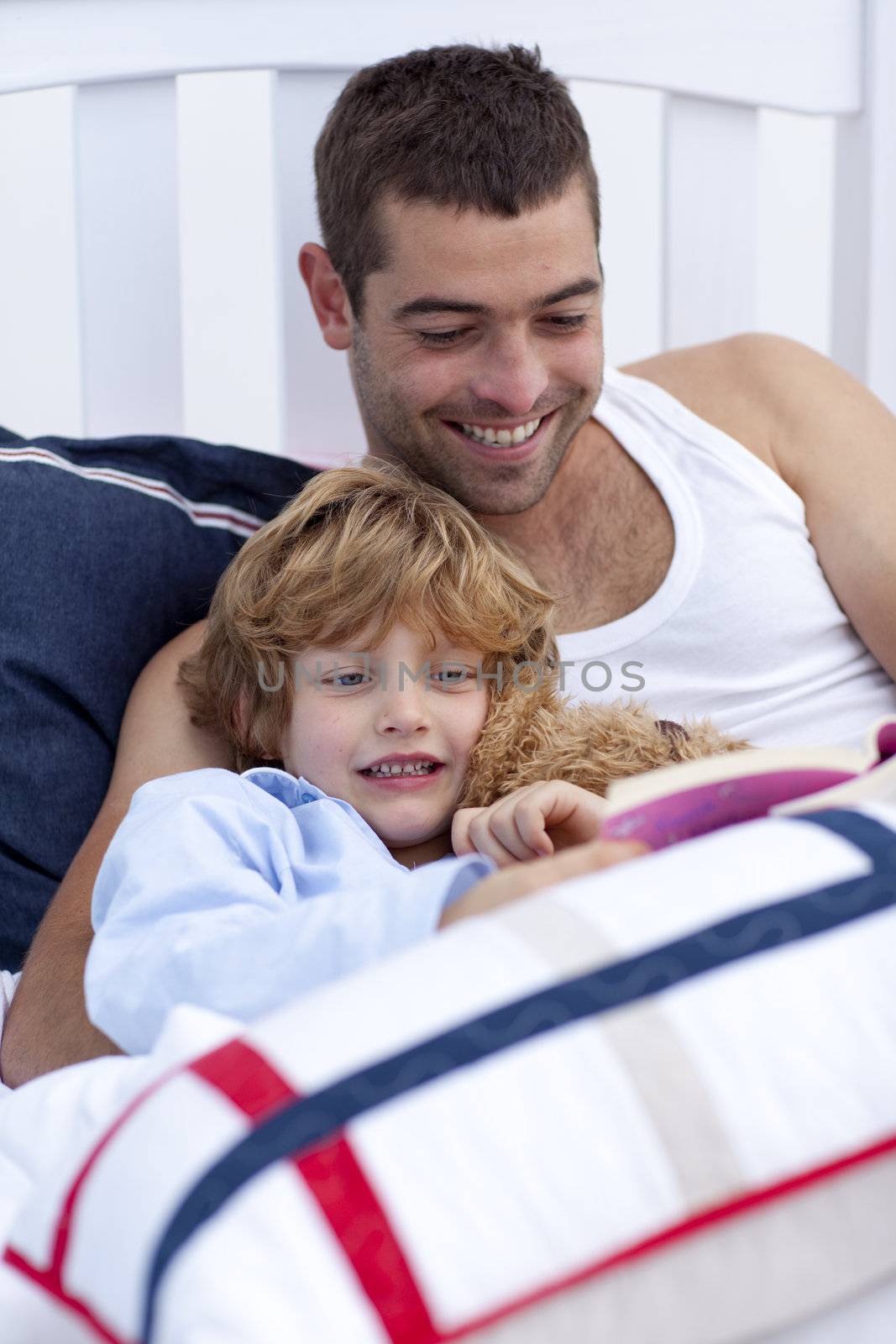 Dad and kid reading a book in bed together