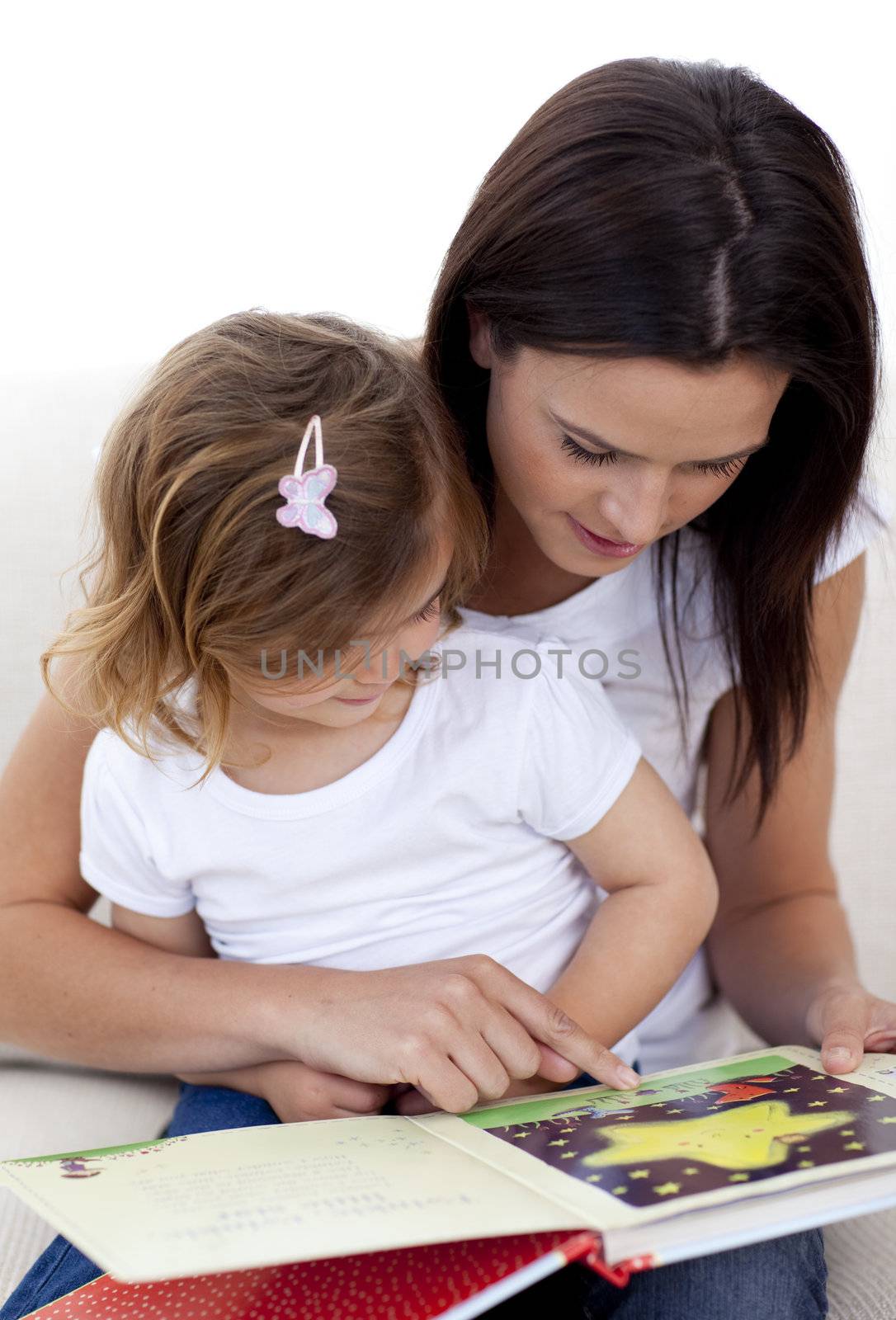 Mother and daughter reading a book in living-room