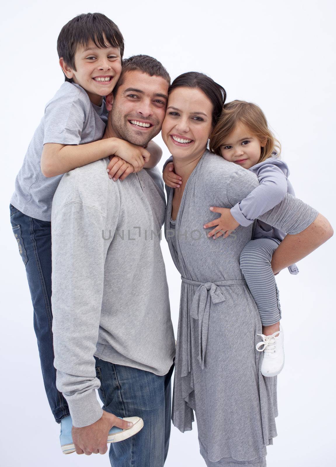 Happy parents giving children piggyback rides at home