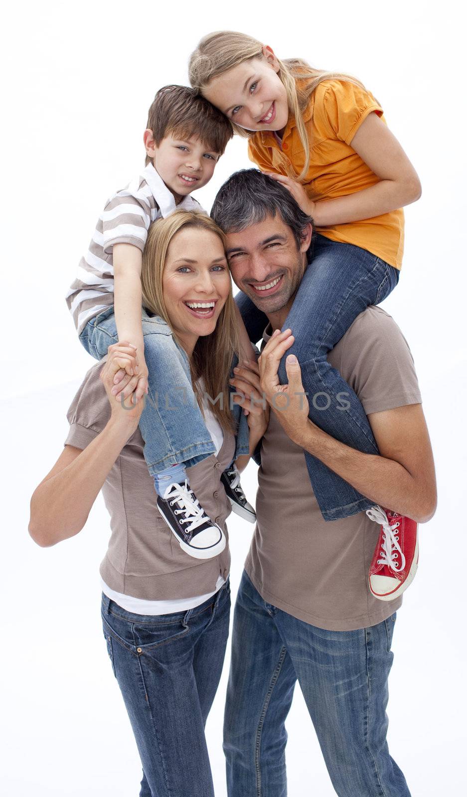 Mother and father giving children piggy back ride against white background