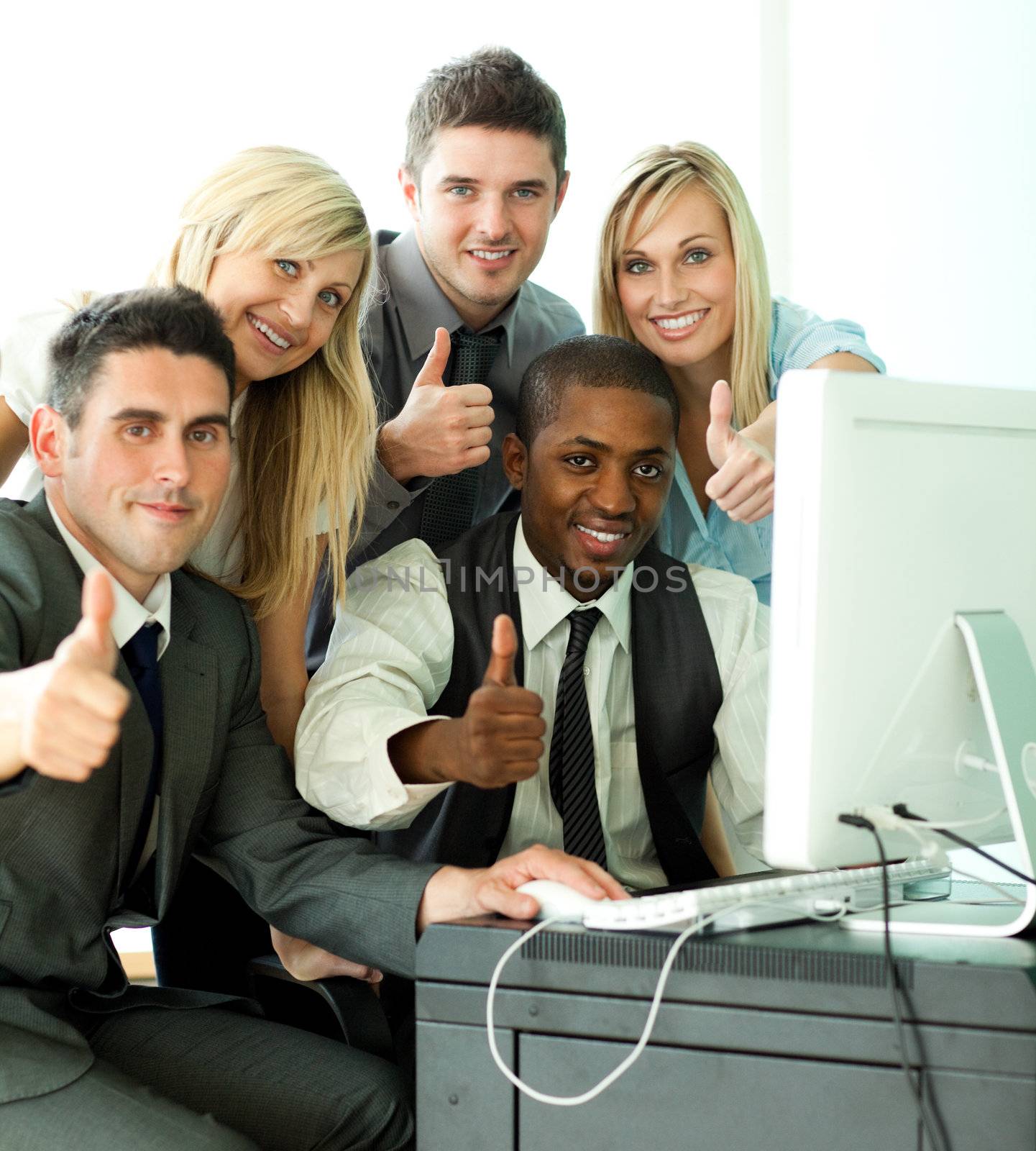 Young business team working in office with thumbs up