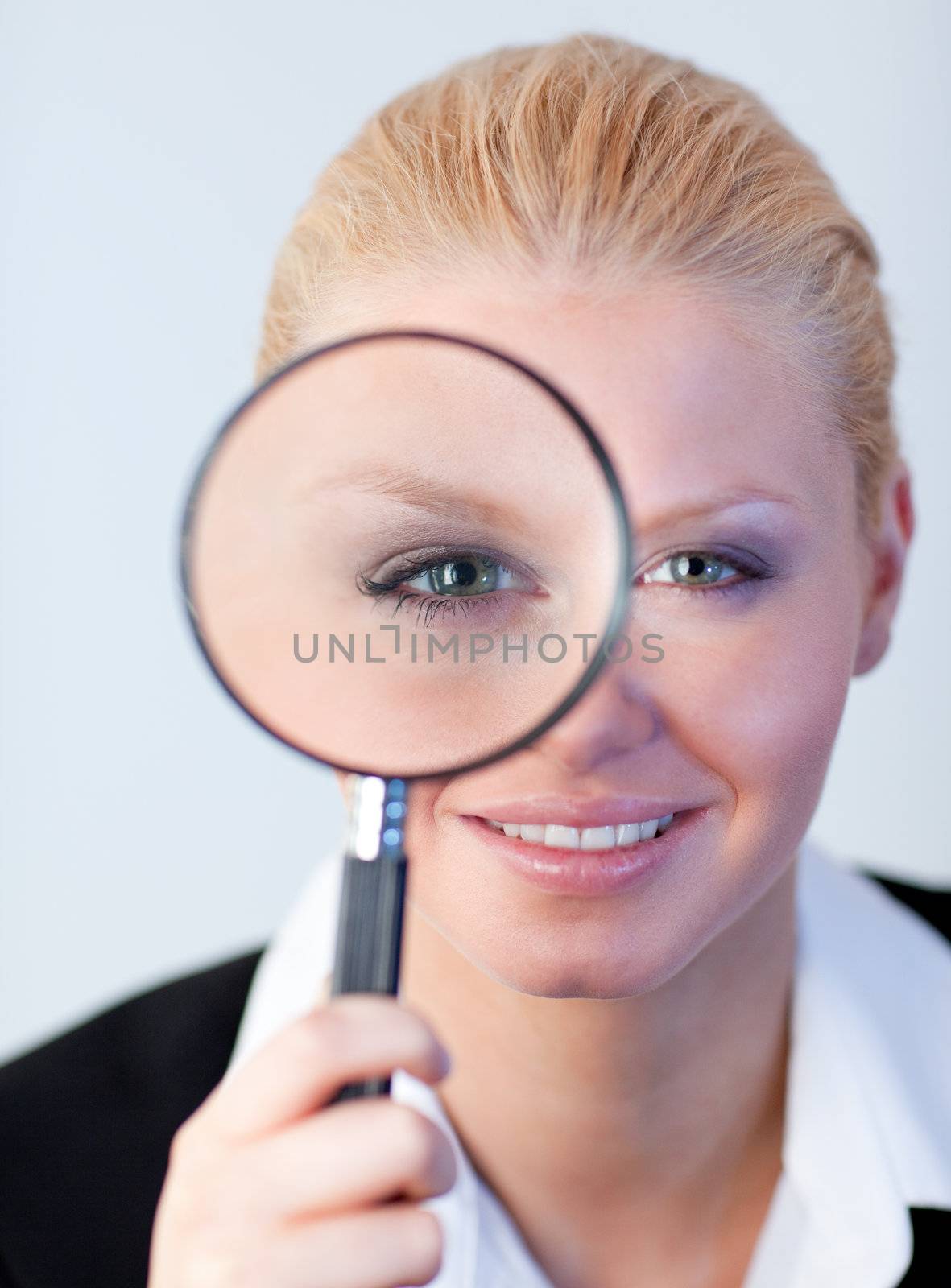 young attractive Smiling woman looking into a magniying glass