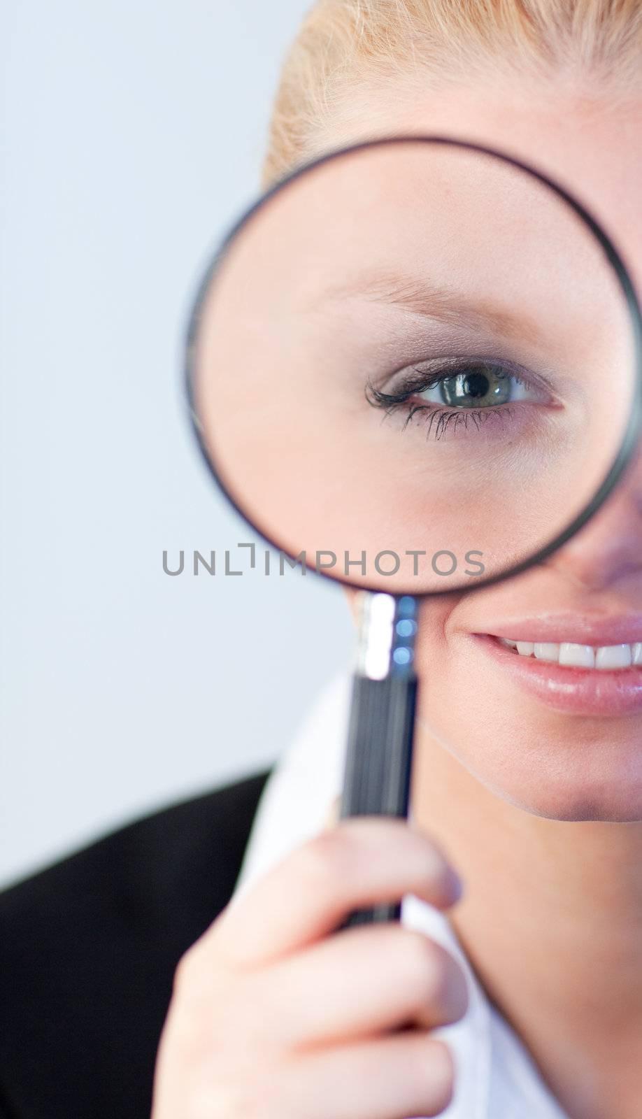Smiling woman looking into a magniying glass by Wavebreakmedia