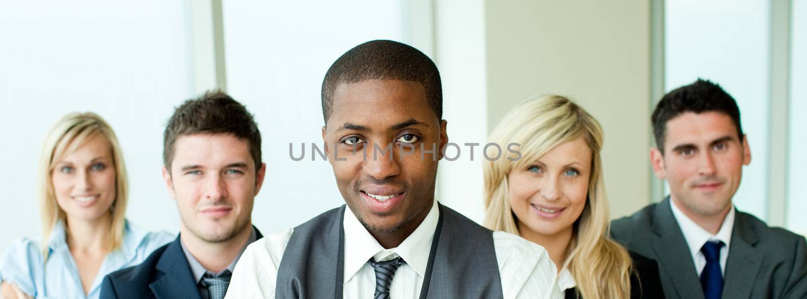 Business team in a row with ethnic manager in the center in office
