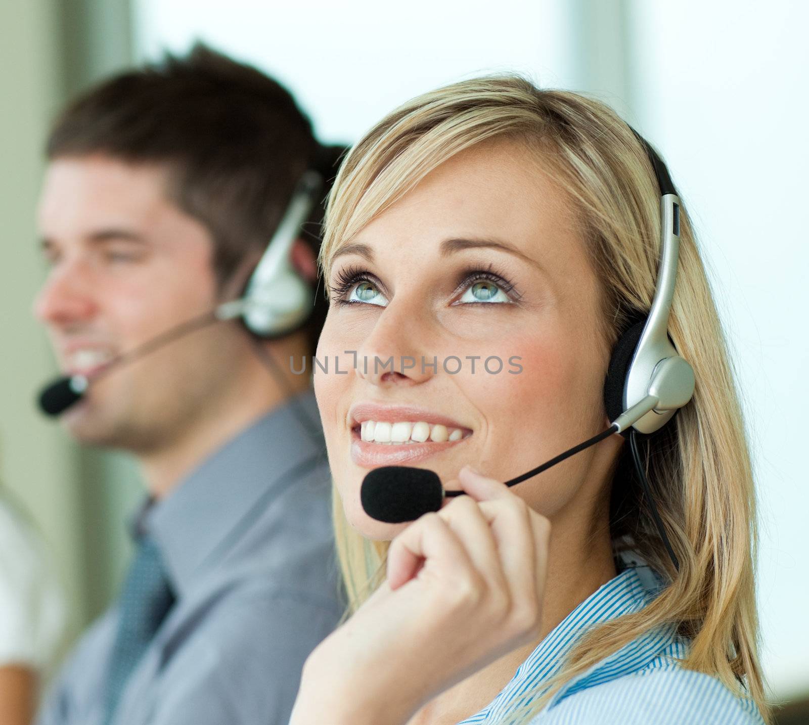 Two business people with headsets in an office