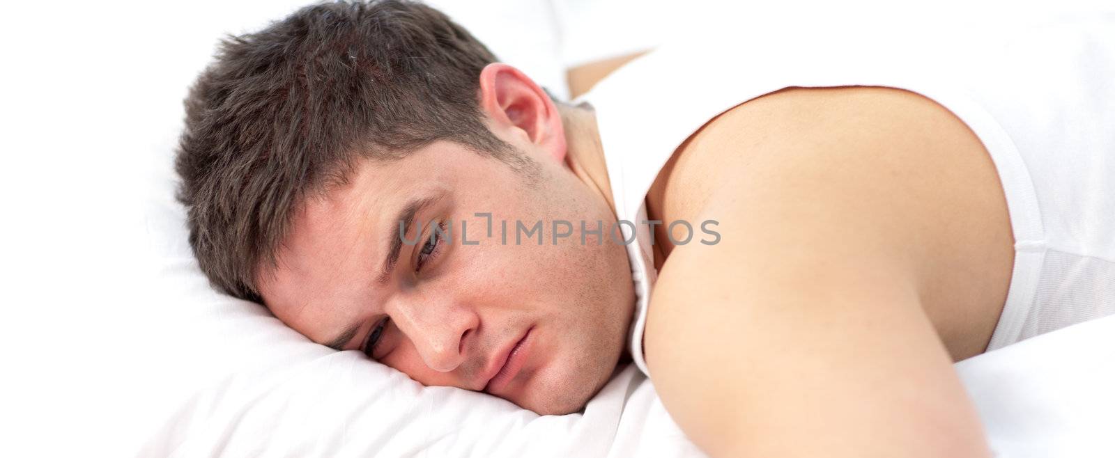 Man sleeping on white bed 