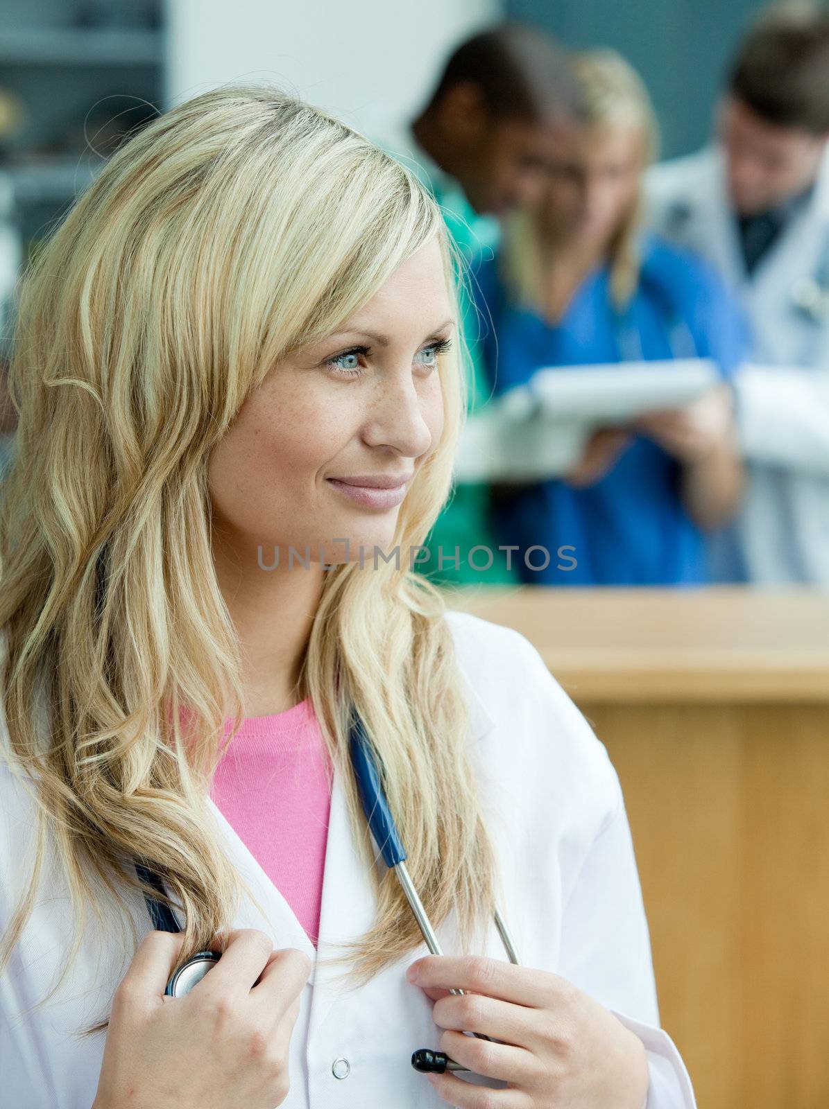 Portrait of a smiling female surgeon with her team behind her by Wavebreakmedia