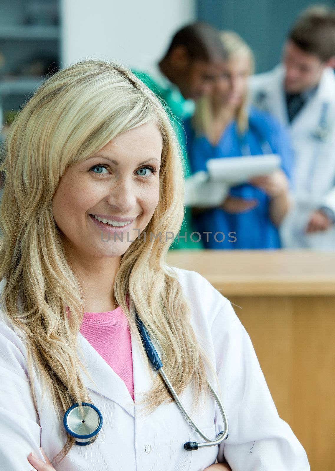 Portrait of a radiant female surgeon with her team behind her
