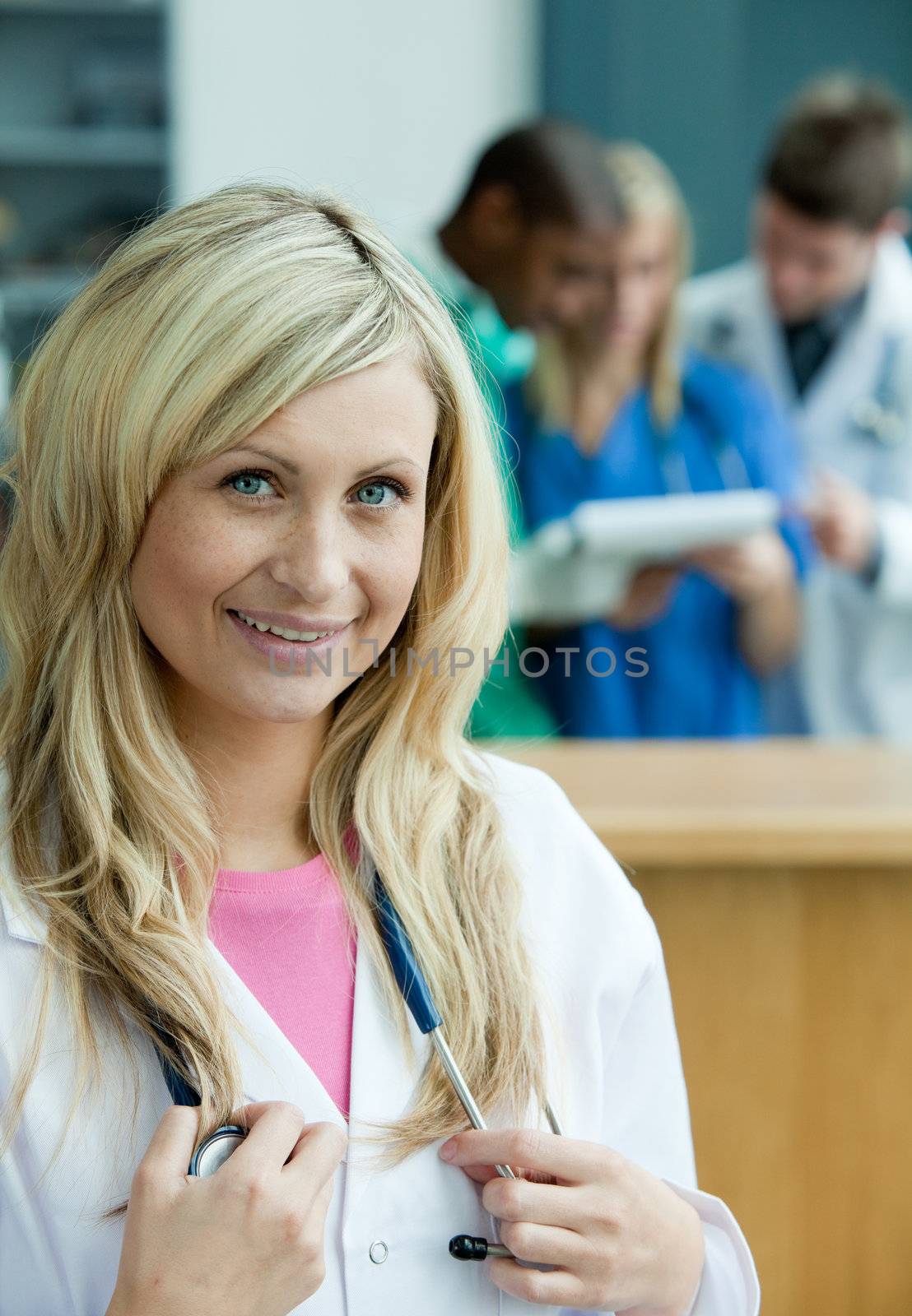 Portrait of a beautiful female surgeon with her team behind her