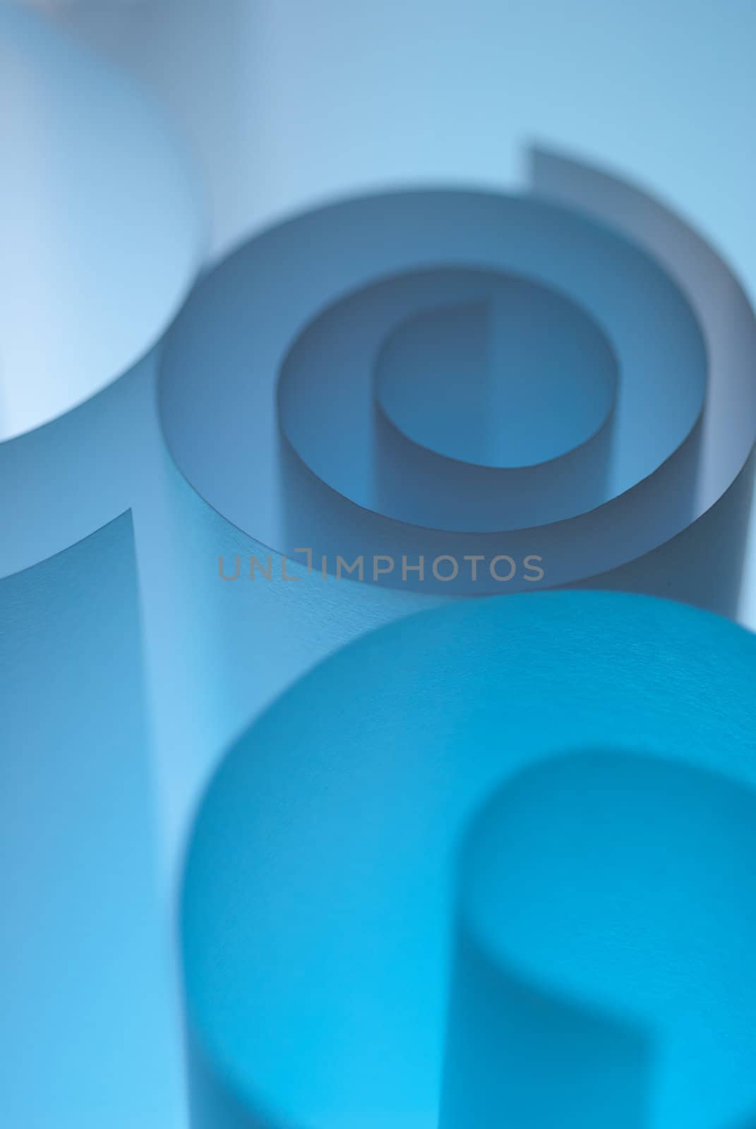 Blue paper curls with selective focus play in studio