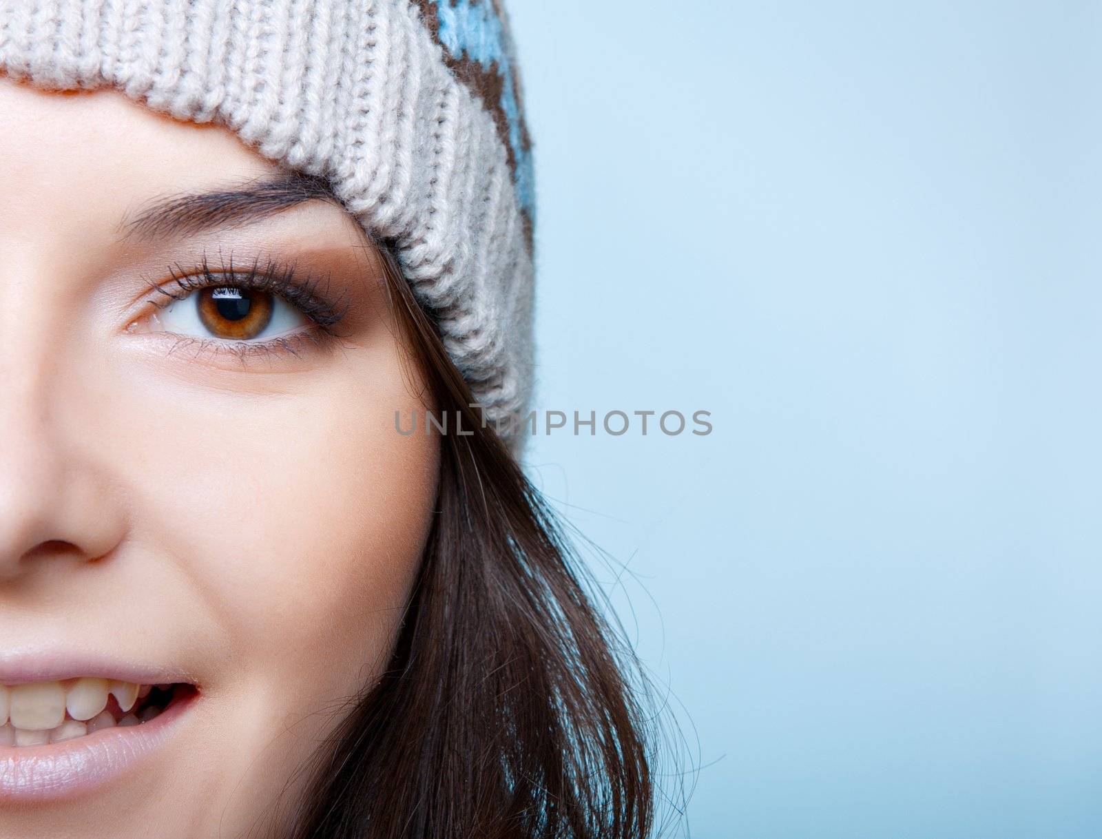 half of face of winter woman on blue background