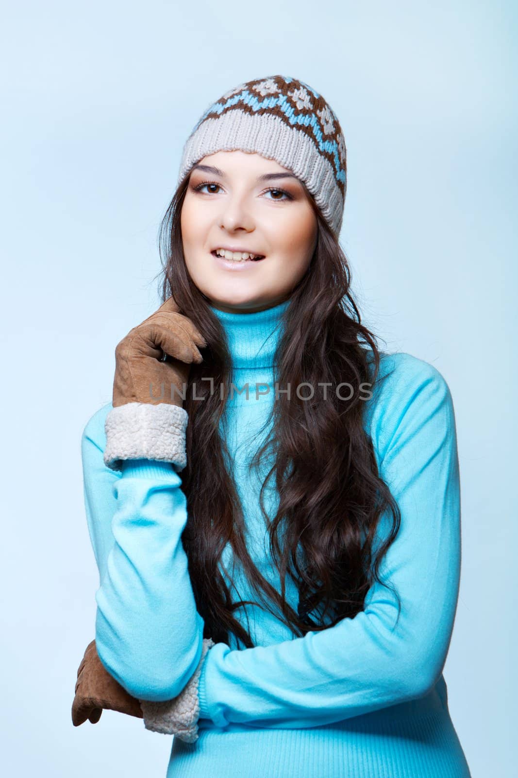 smiling woman in cap and mittens on blue background