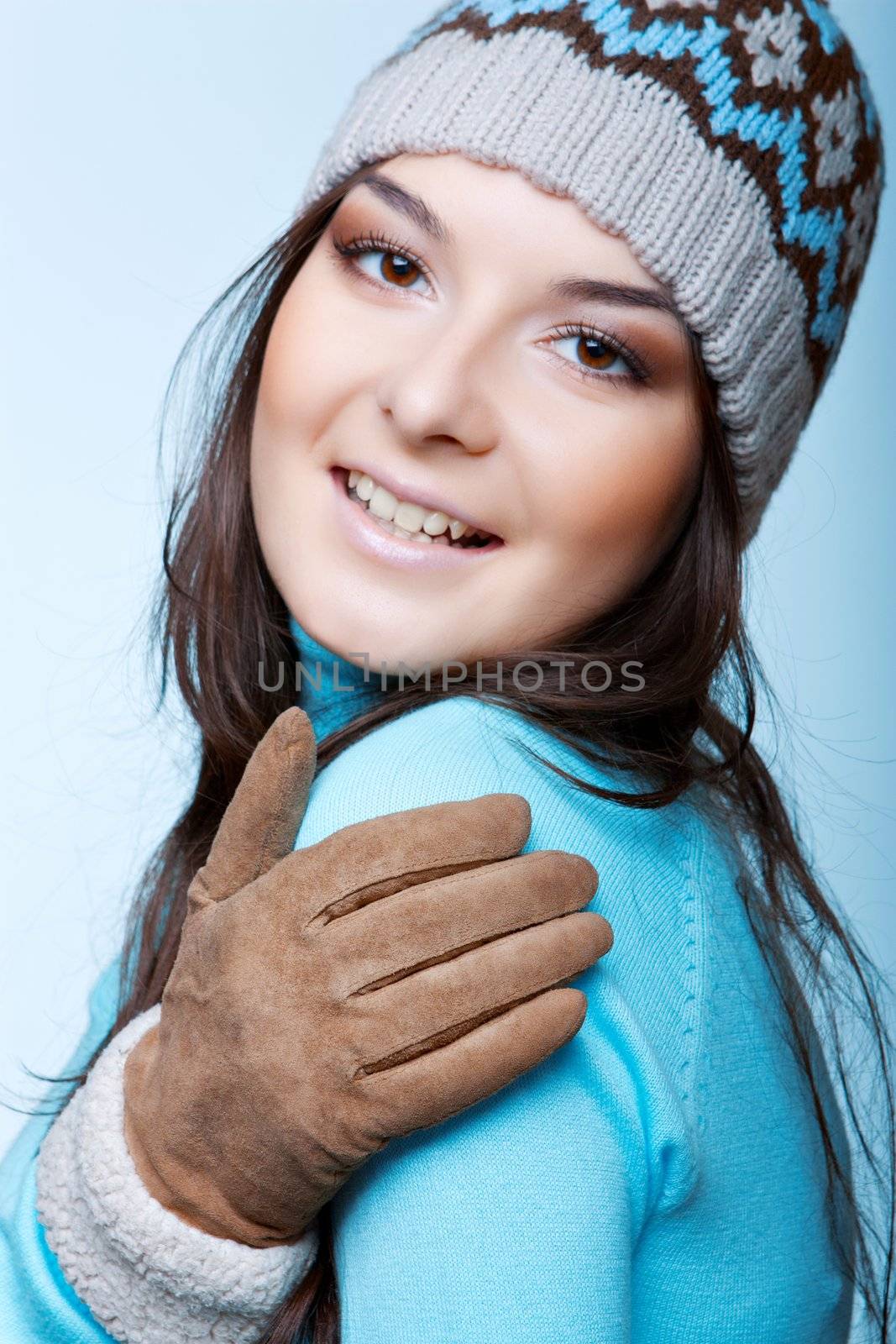 Smiling woman in a cap on the blue background