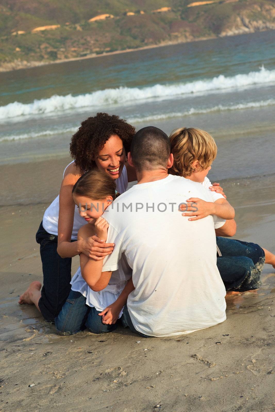 Smiling family on a beach by Wavebreakmedia