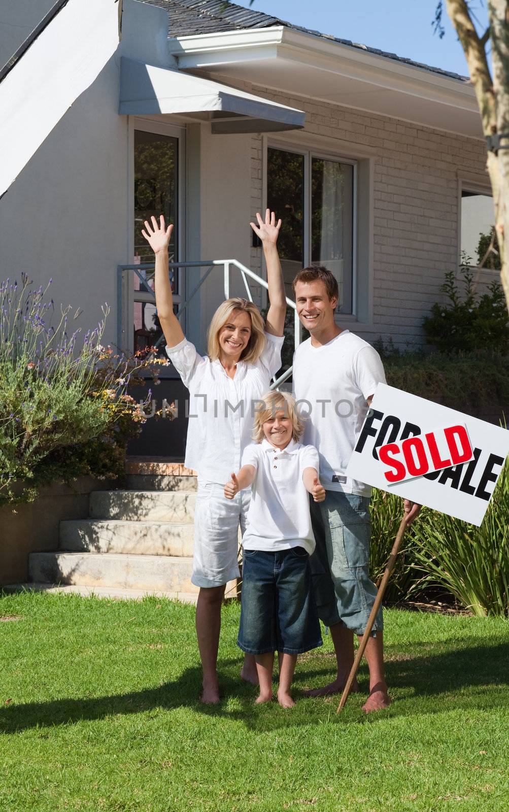 Happy family with their new home in the garden