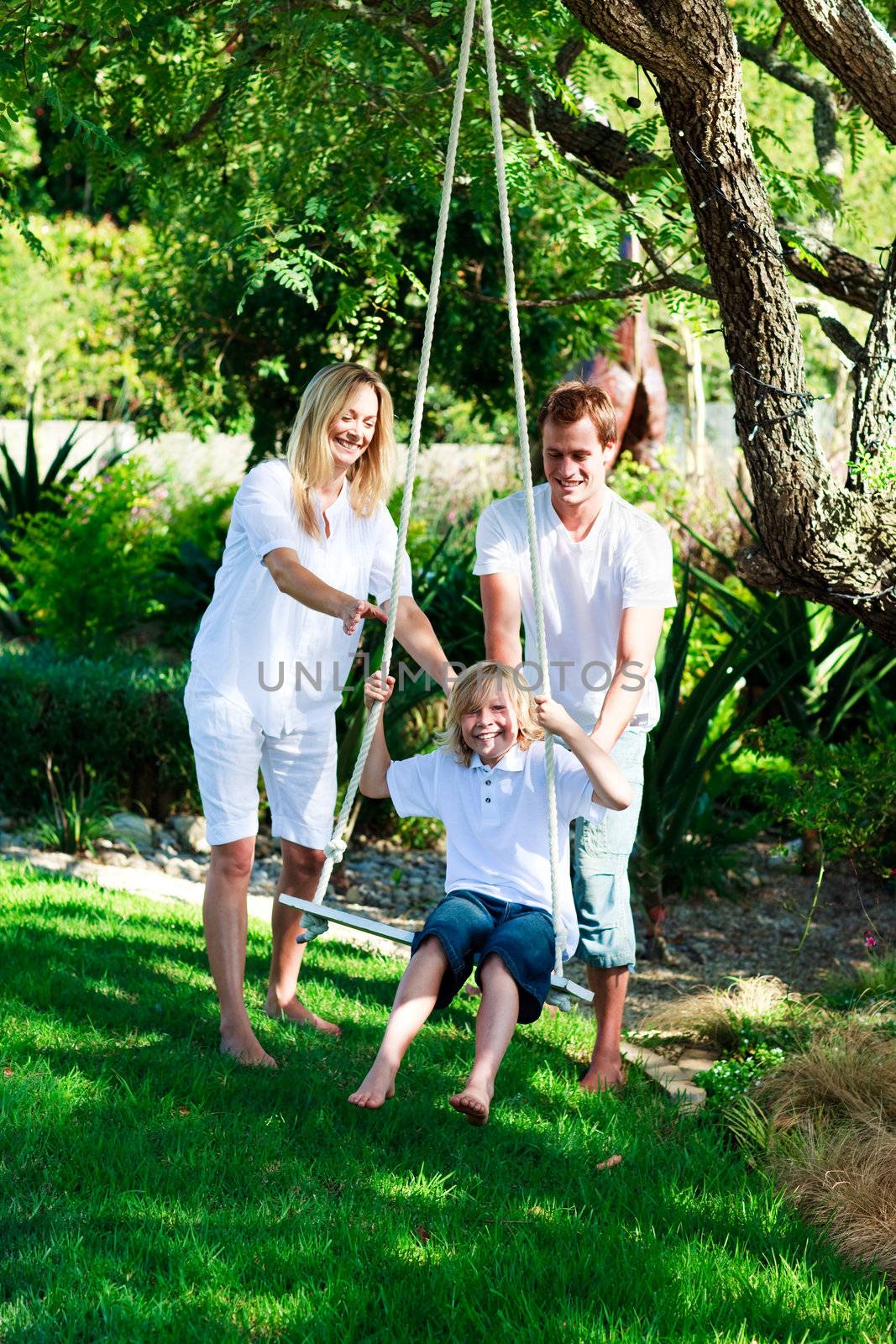Happy familiy having fun swinging  by Wavebreakmedia