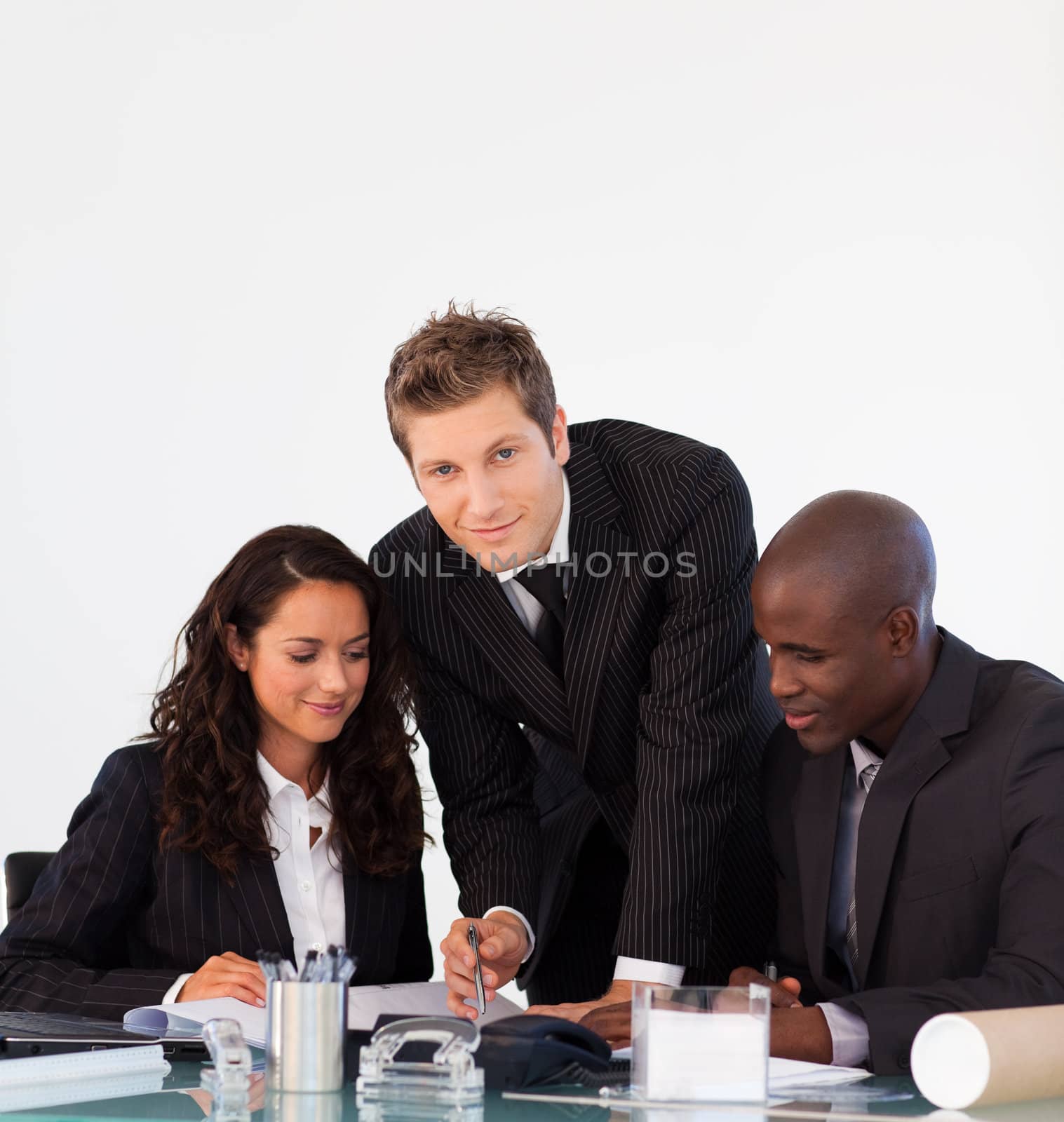 Young business people dicussing in an office and looking at the camera
