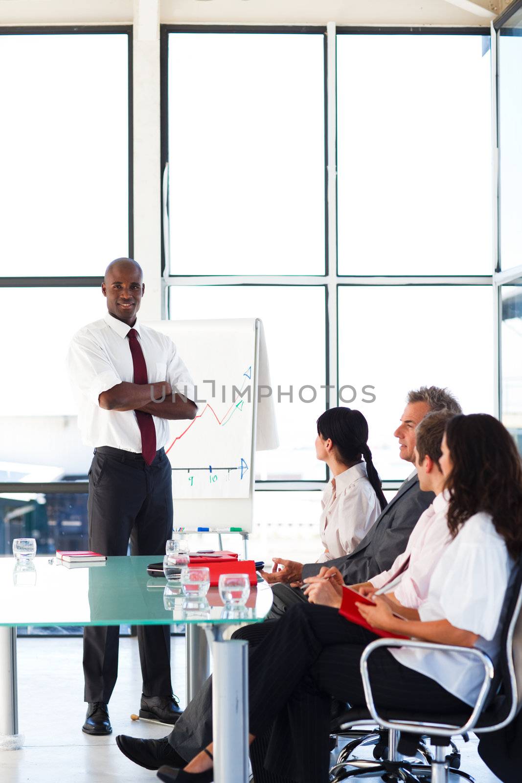 Attractive young businessman with folded arms in a meeting