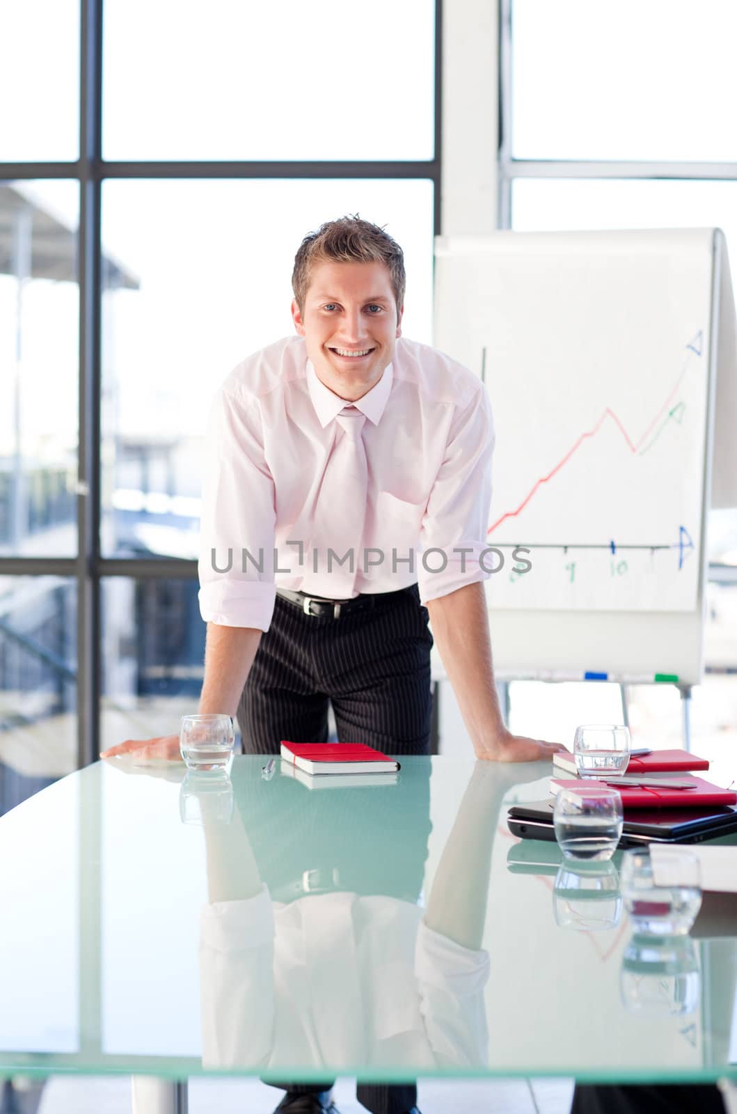 Smiling young businessman standing in a presentation