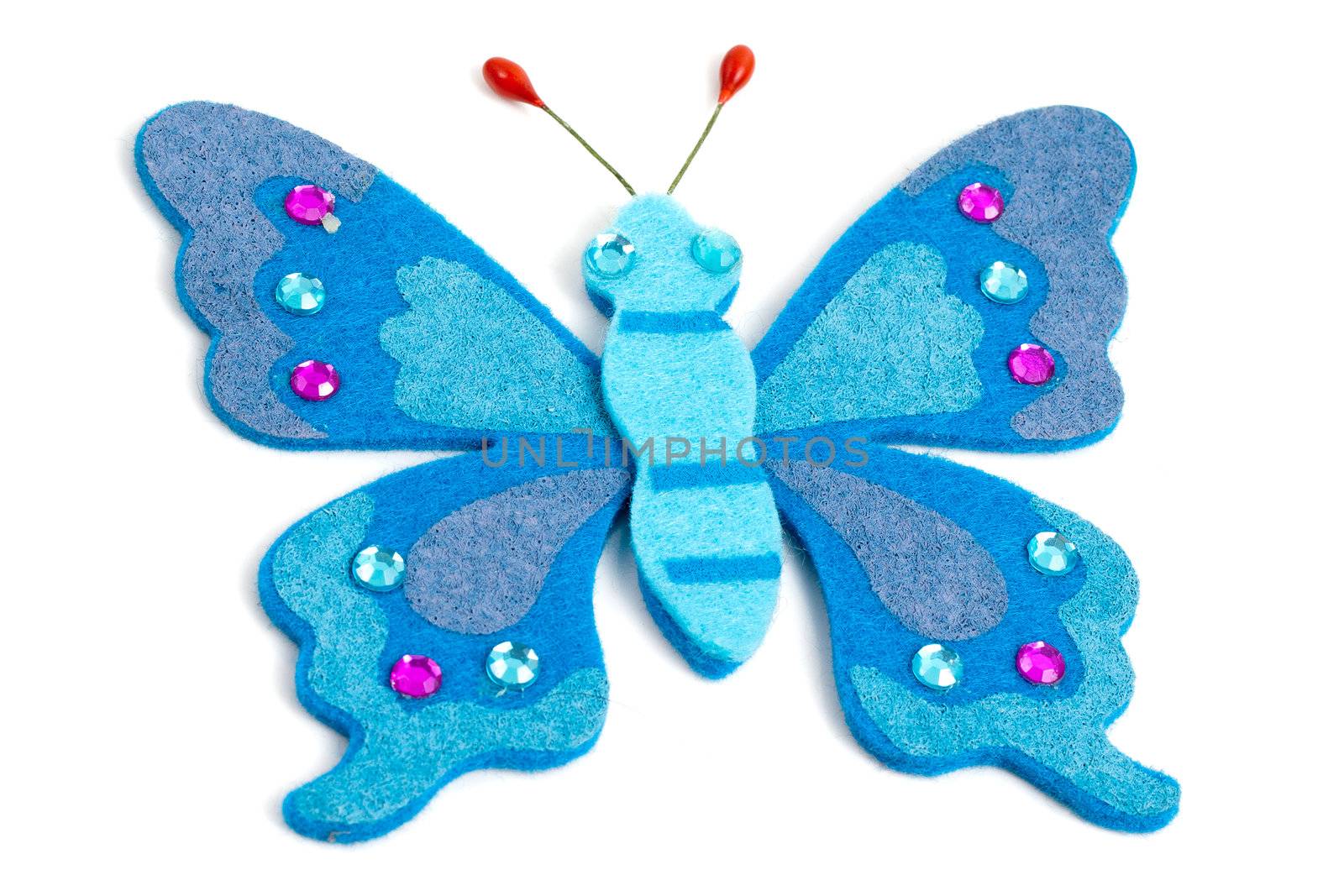 Artistic butterfly made from blue fabric, white studio background