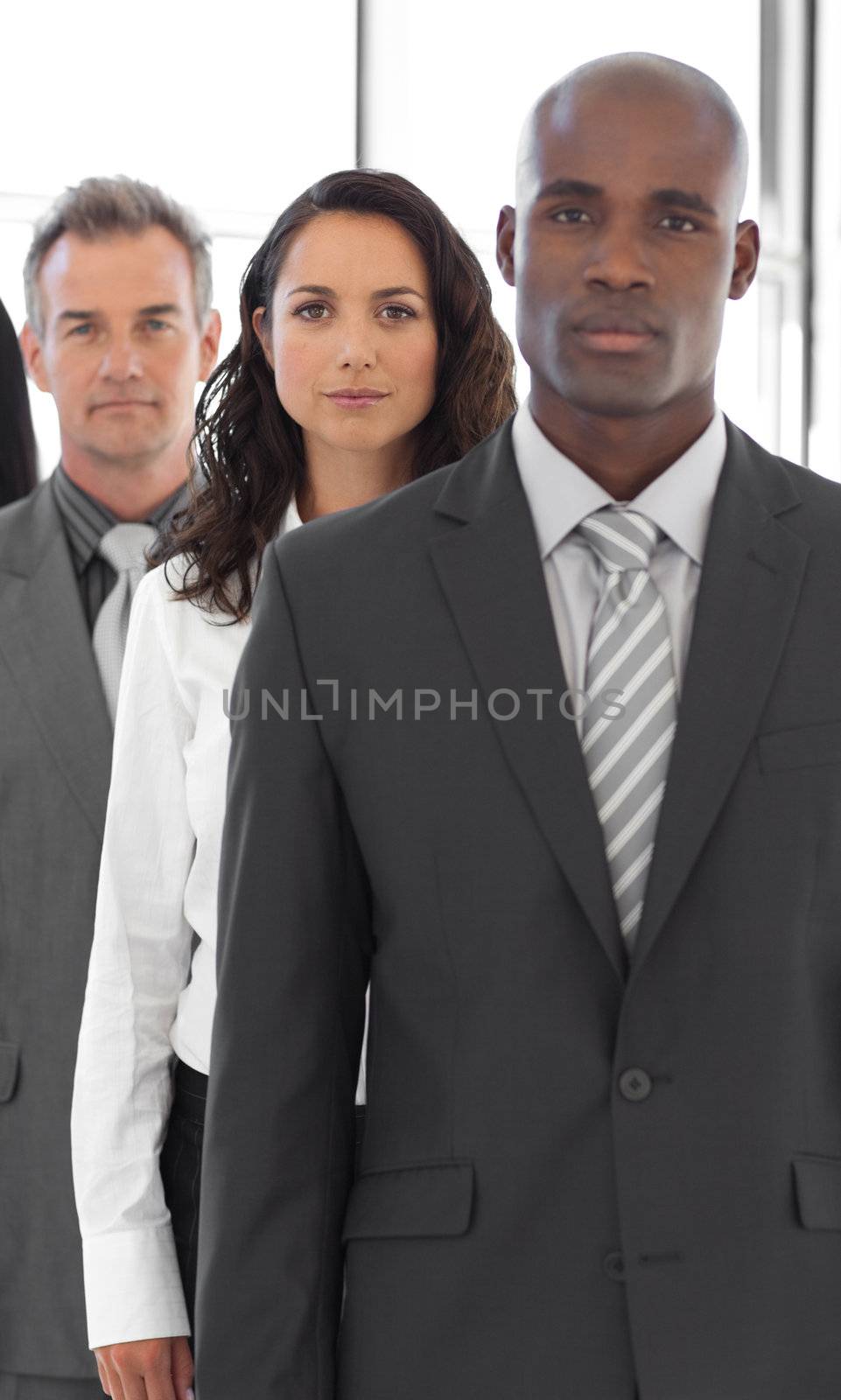 Business man looking at camera with group in background