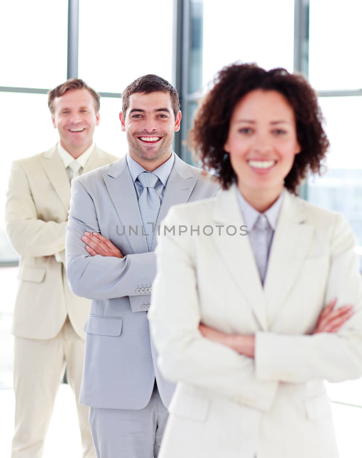 Attractive smiling businessman with folded arms in a row