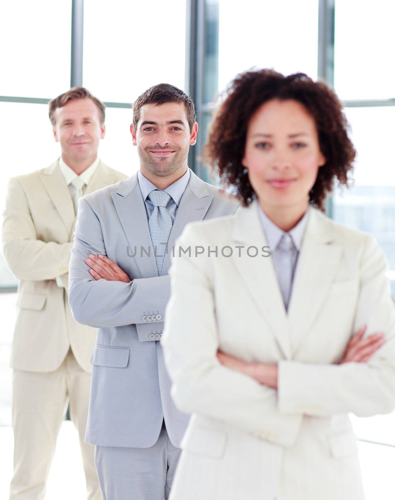 Attractive confident businessman with folded arms in a row