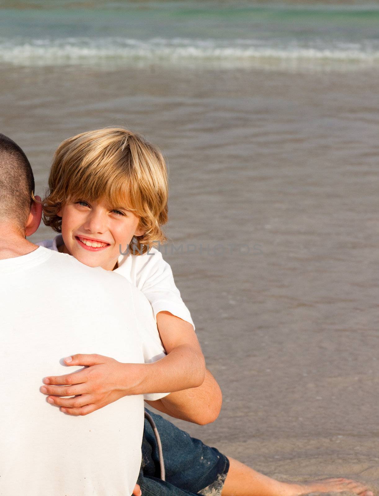 Blond boy and his father on a beach by Wavebreakmedia