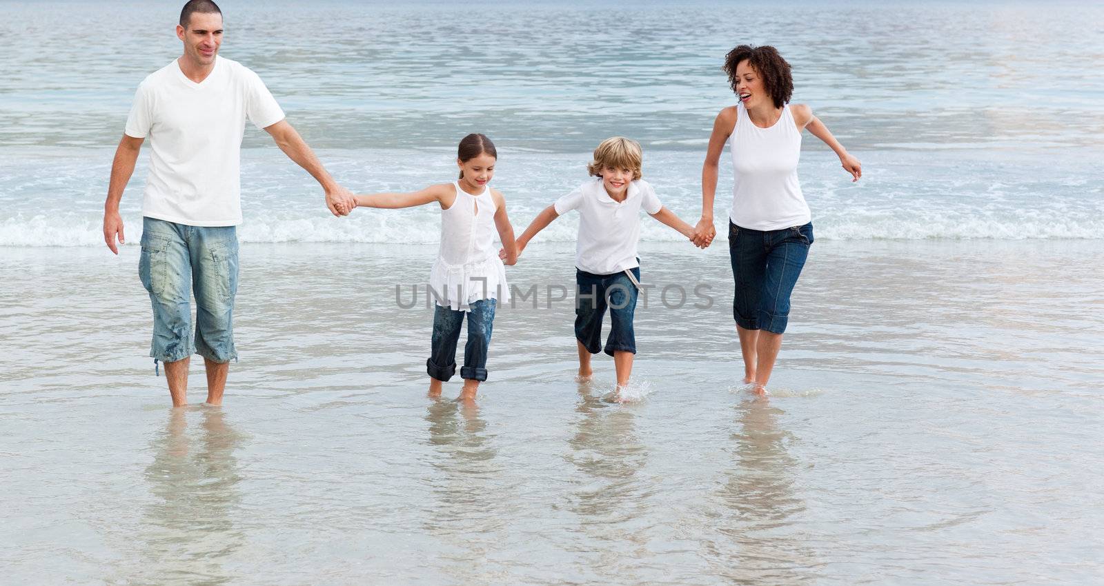 Family walking on the beach by Wavebreakmedia