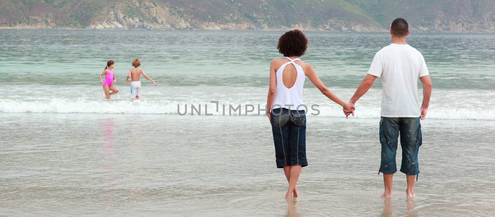 Couple walking on the beach by Wavebreakmedia