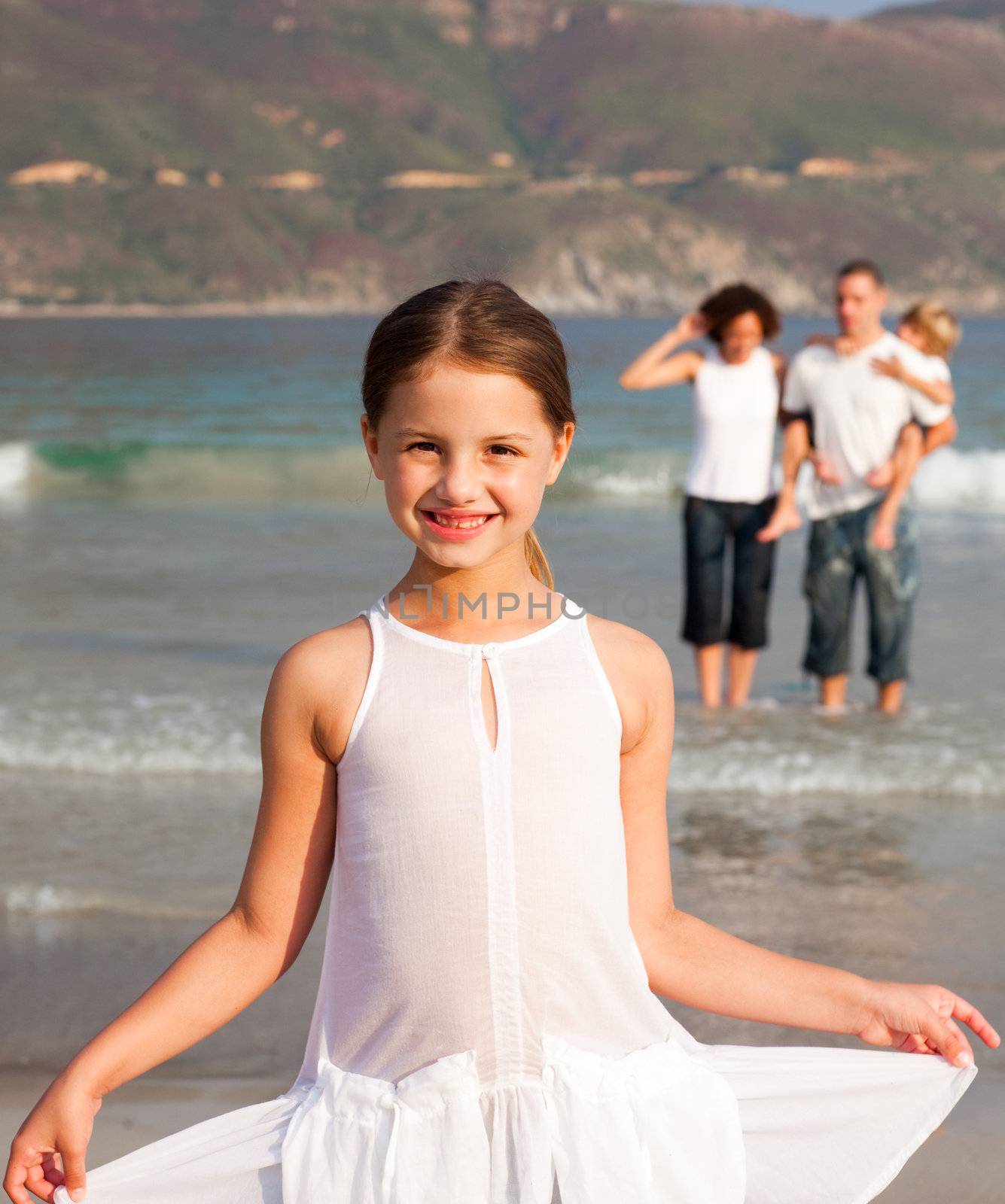 Nice girl on a beach with her parents and her brother in background by Wavebreakmedia
