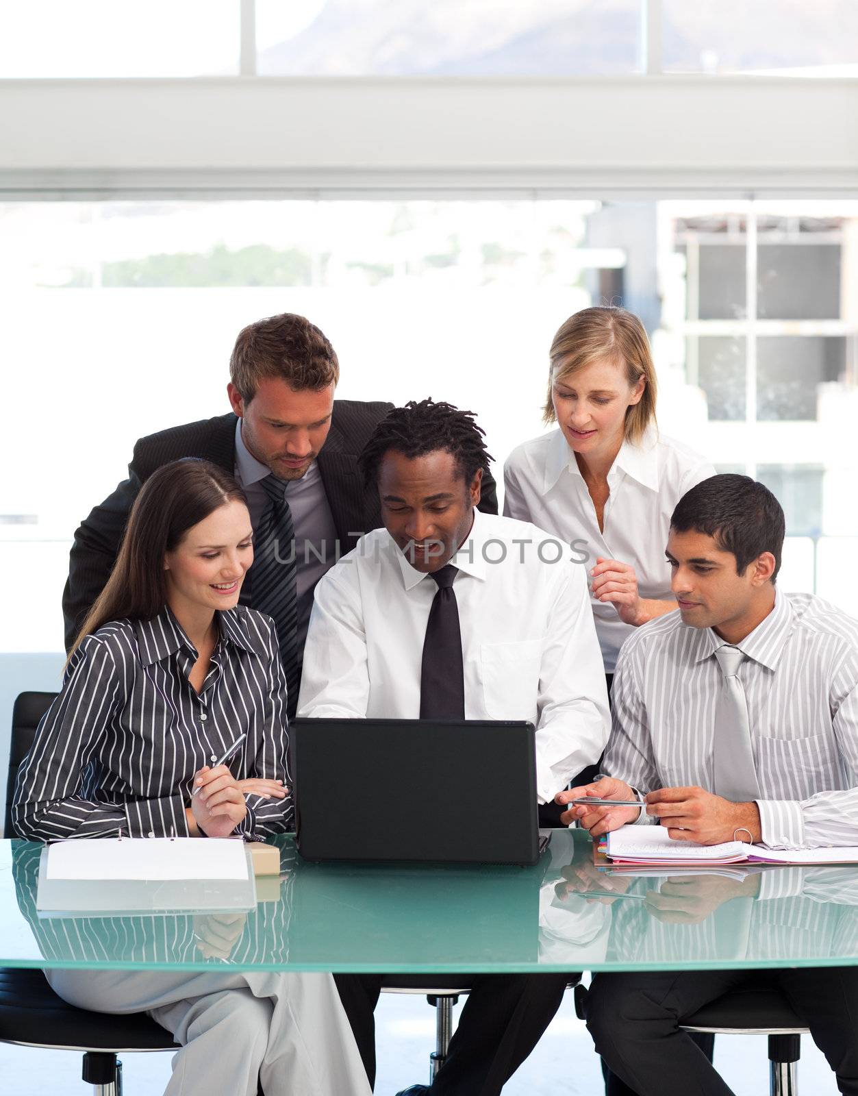 Business people using a laptop together by Wavebreakmedia