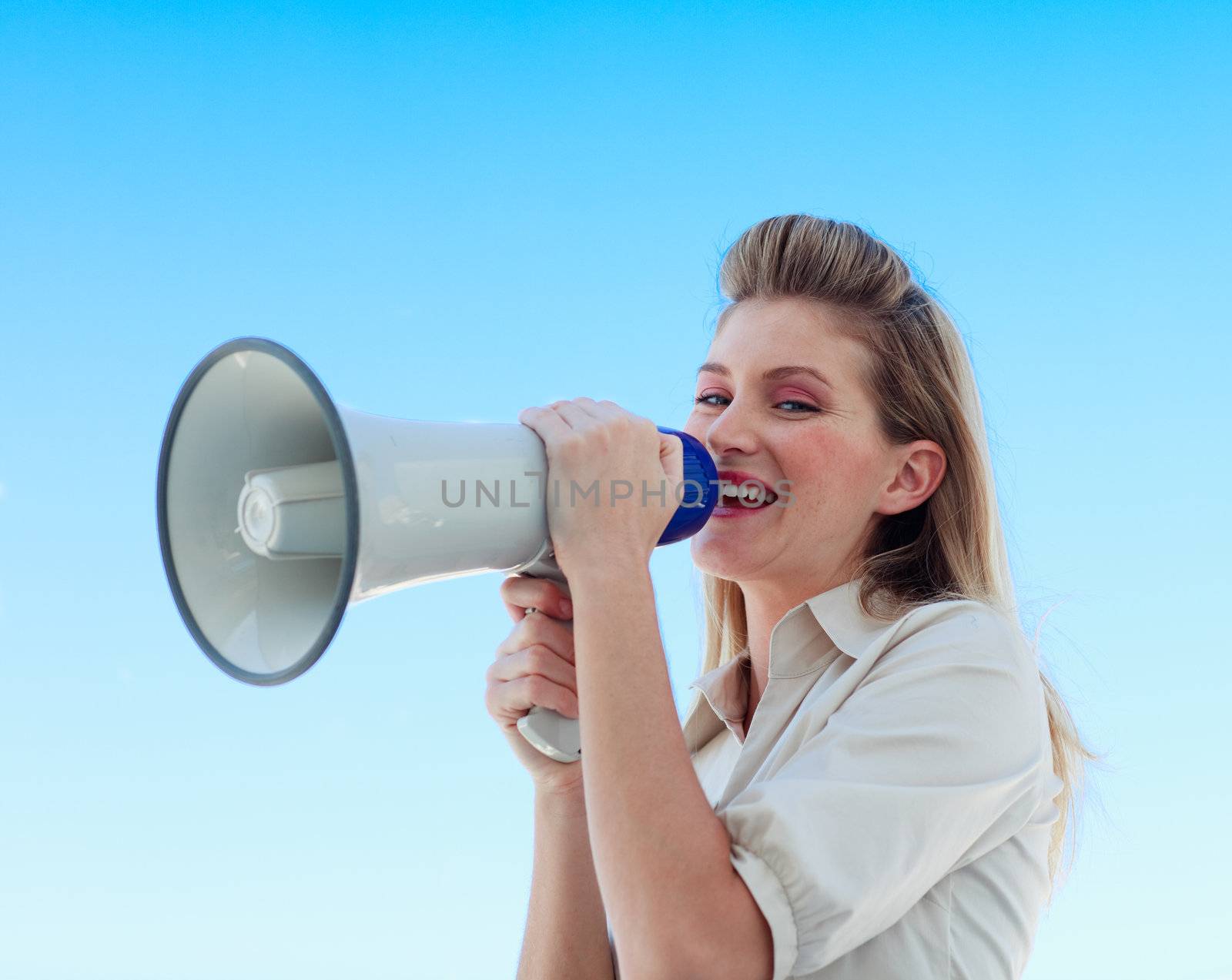Beautiful businesswoman shouting through megaphone by Wavebreakmedia