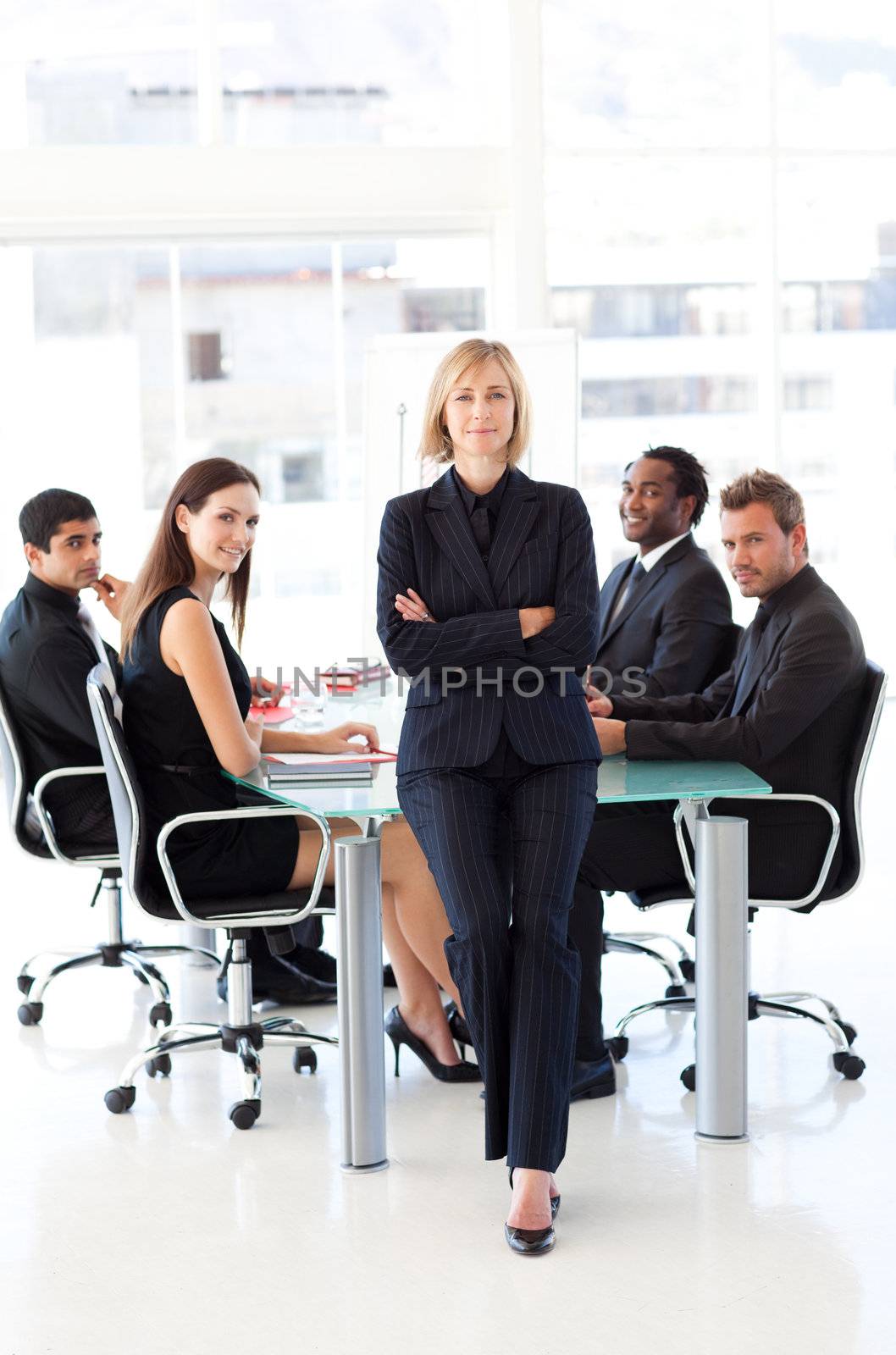 Serious businesswoman with folded arms in a meeting by Wavebreakmedia