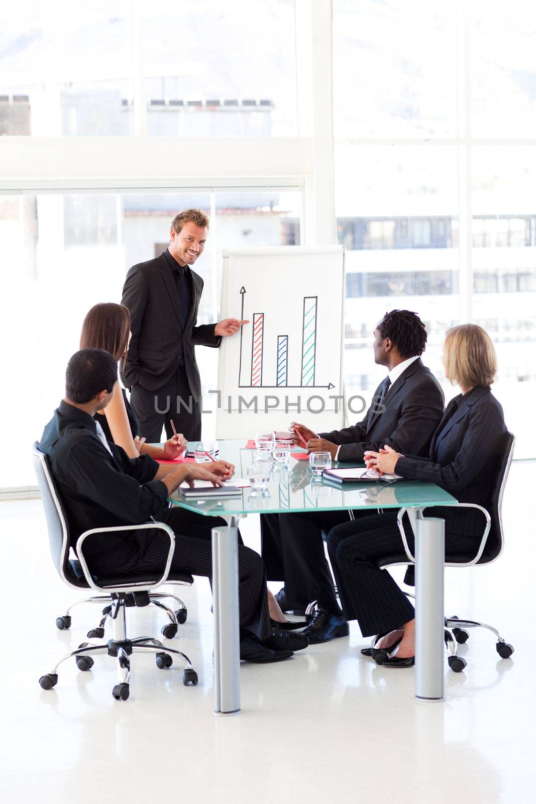 Young businessman reporting to sales to his team in an office