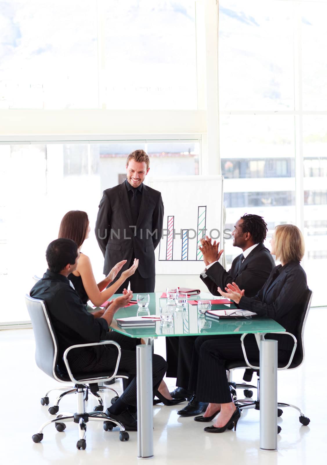 Business people clapping a young colleague in a presentation