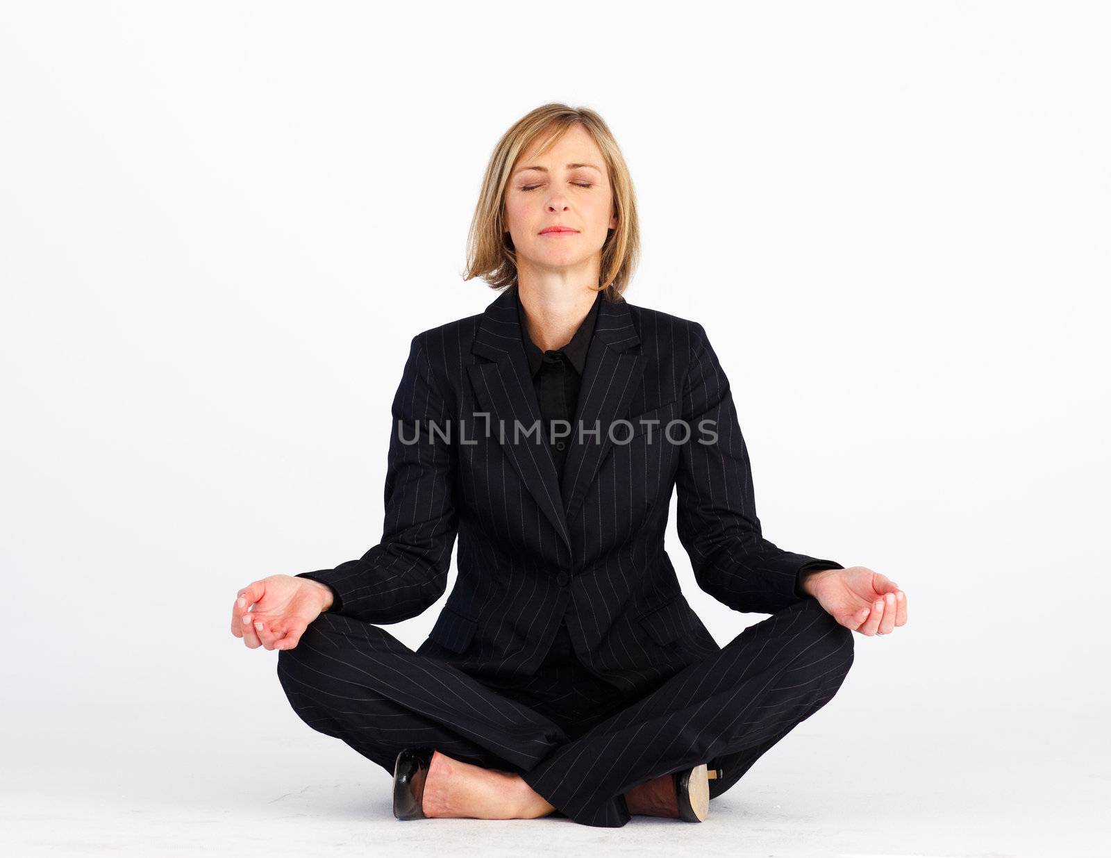 Mature blonde businesswoman meditating with clossed eyes