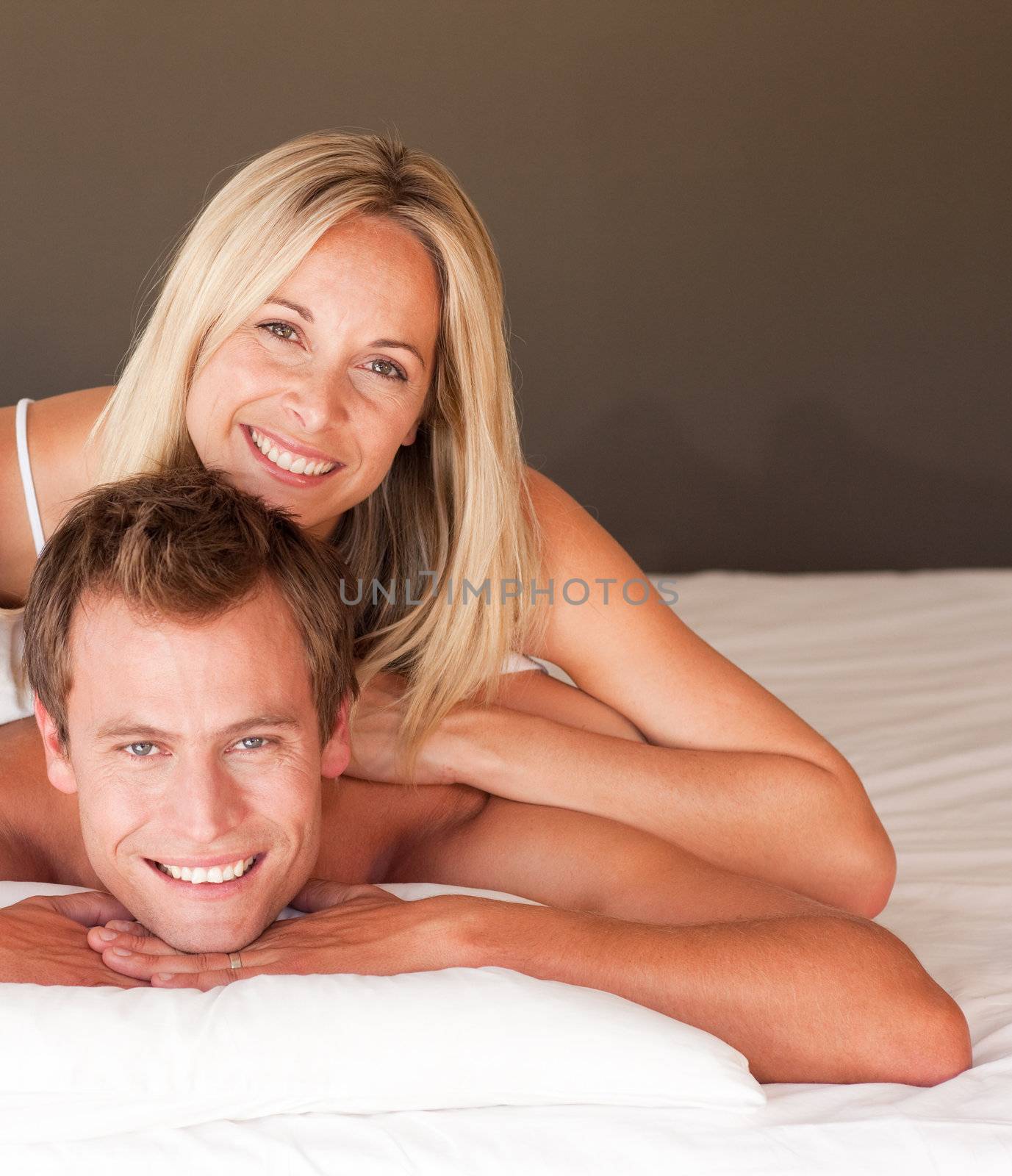 Charming couple enjoying together in bed at home