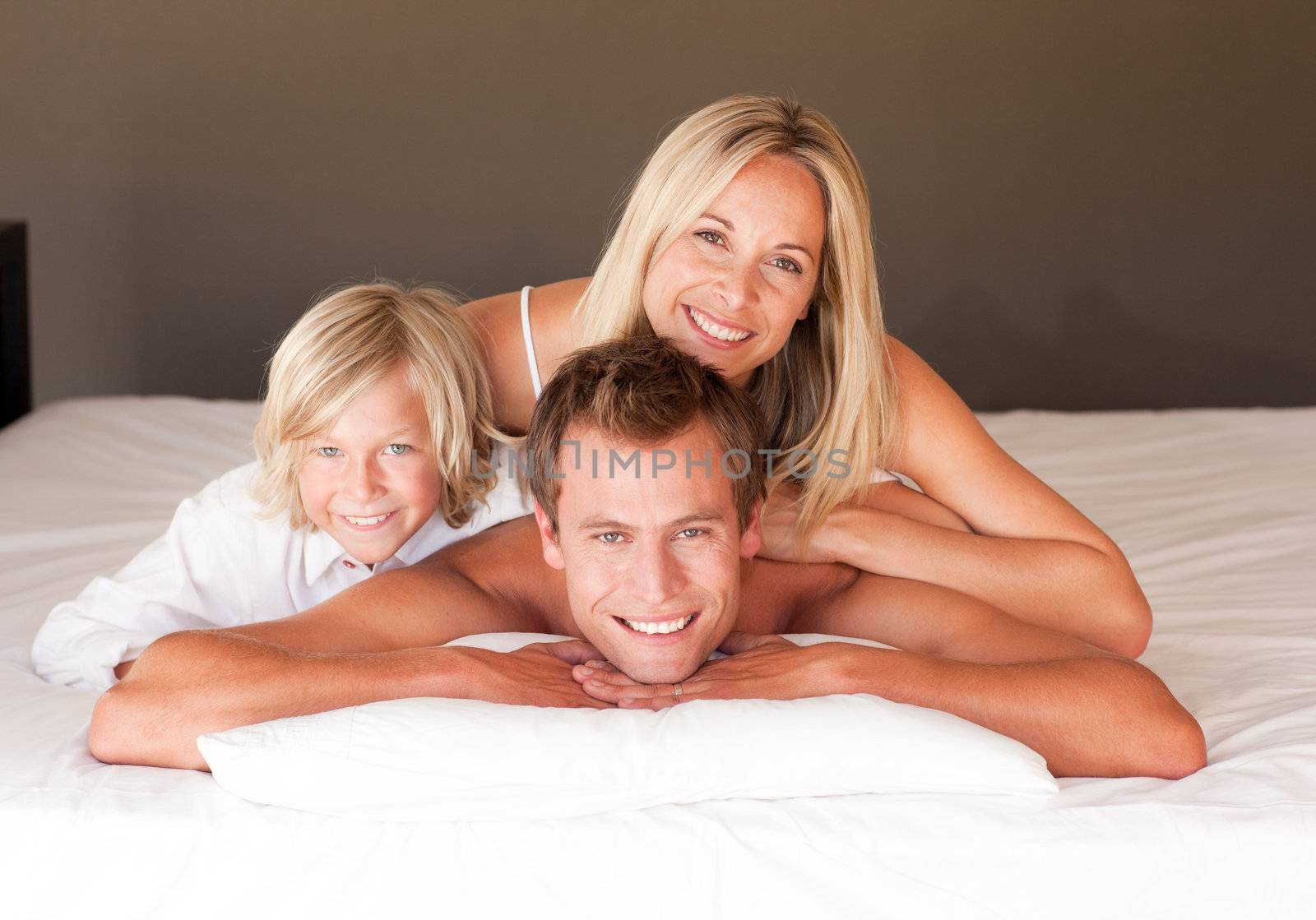 Cute couple and son enjoying together in bed  by Wavebreakmedia