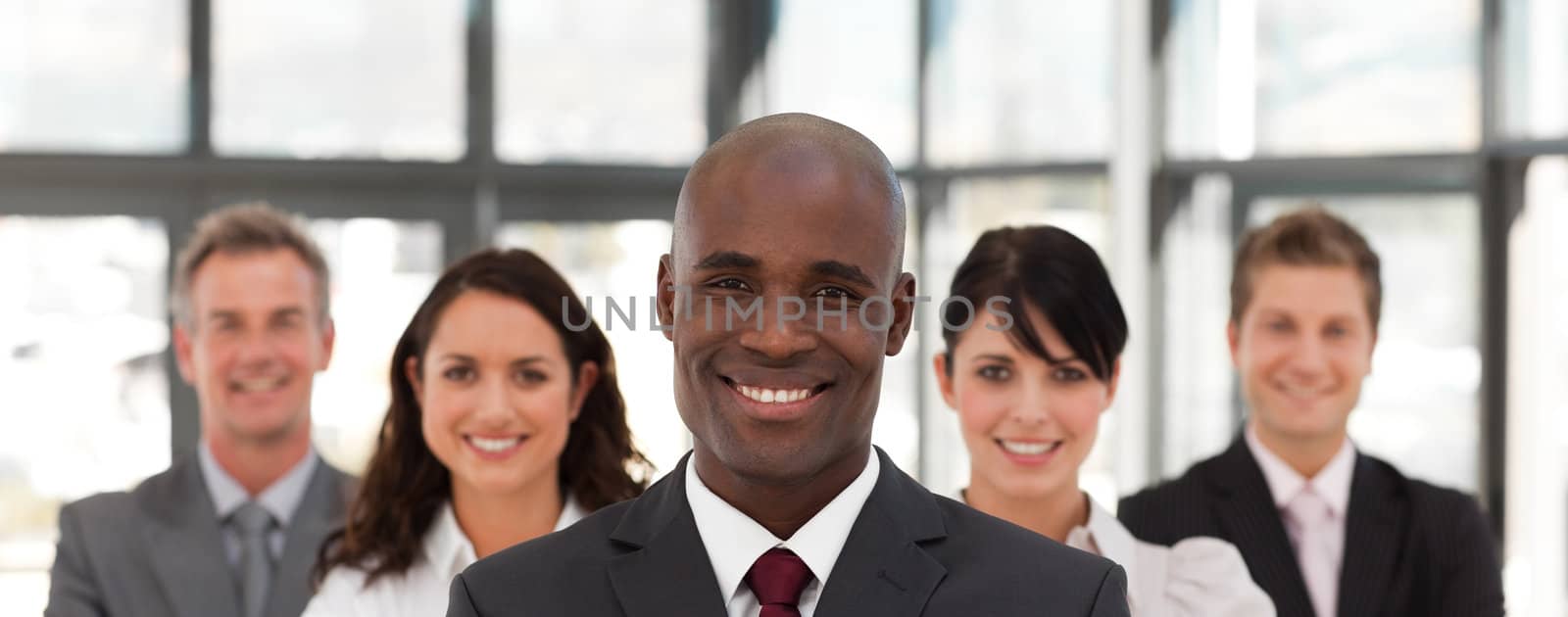 Happy businessman leading a business team in a line in the office