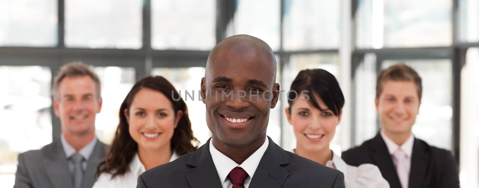 Happy businessman leading a business team in a line in the office