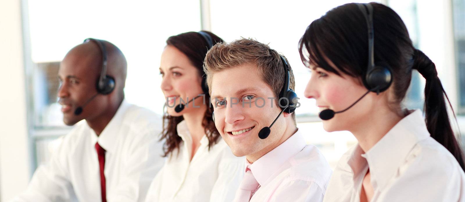 Business called centre with people on headsets in the office