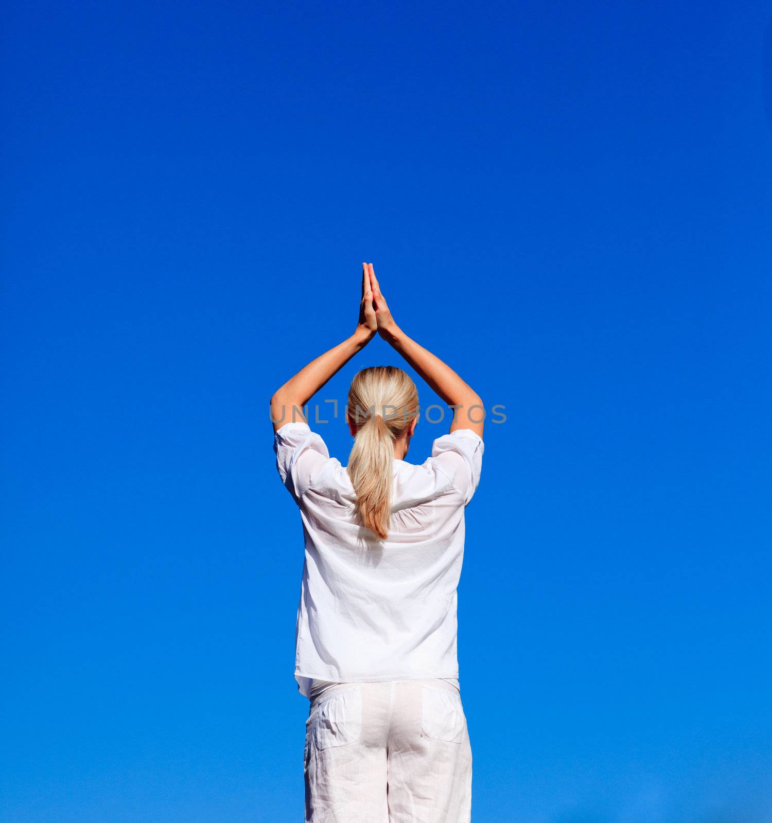 Blond woman practising yoga outdoors