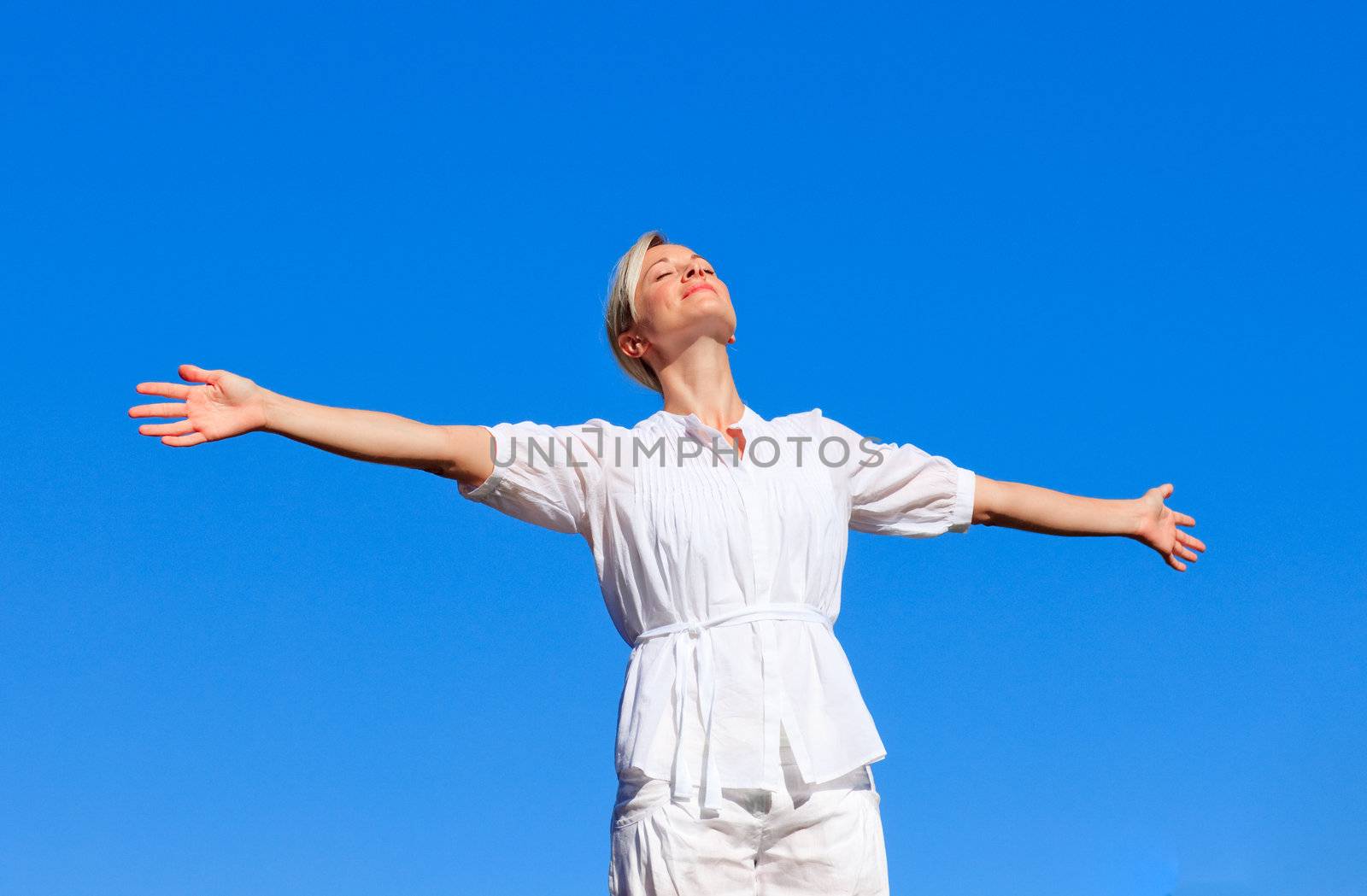 Happy woman with open arms outdoors