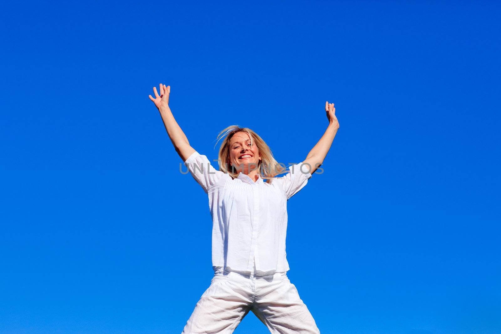 Happy girl jumping against blue sky by Wavebreakmedia