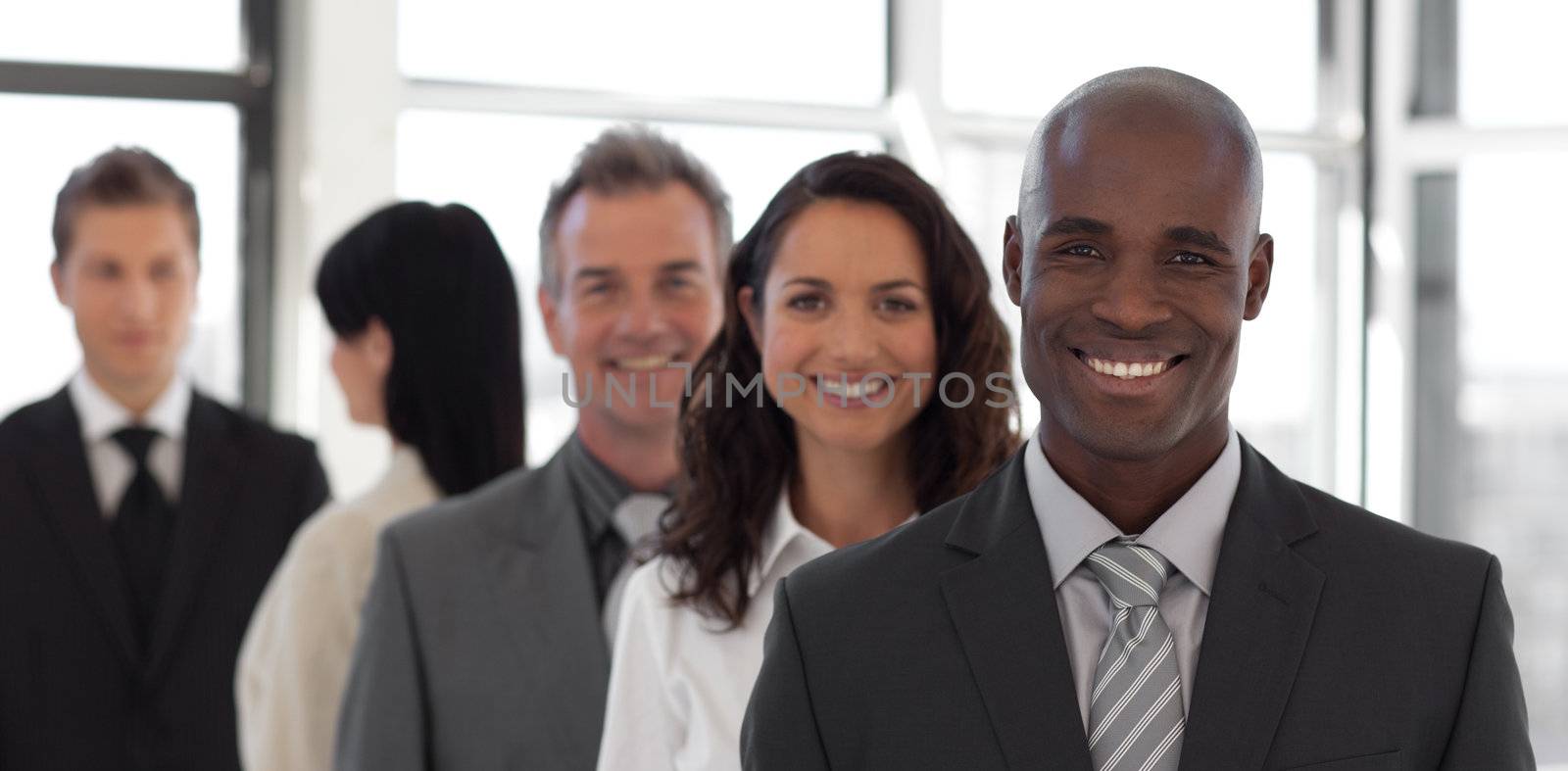 Five person Business team looking at camera and smiling  by Wavebreakmedia