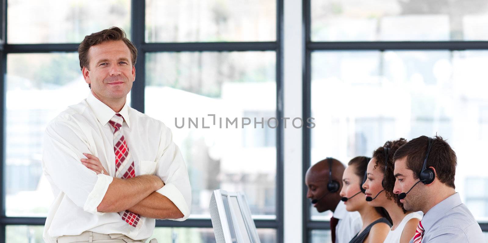 Senior manager with folded arms working in a call center
