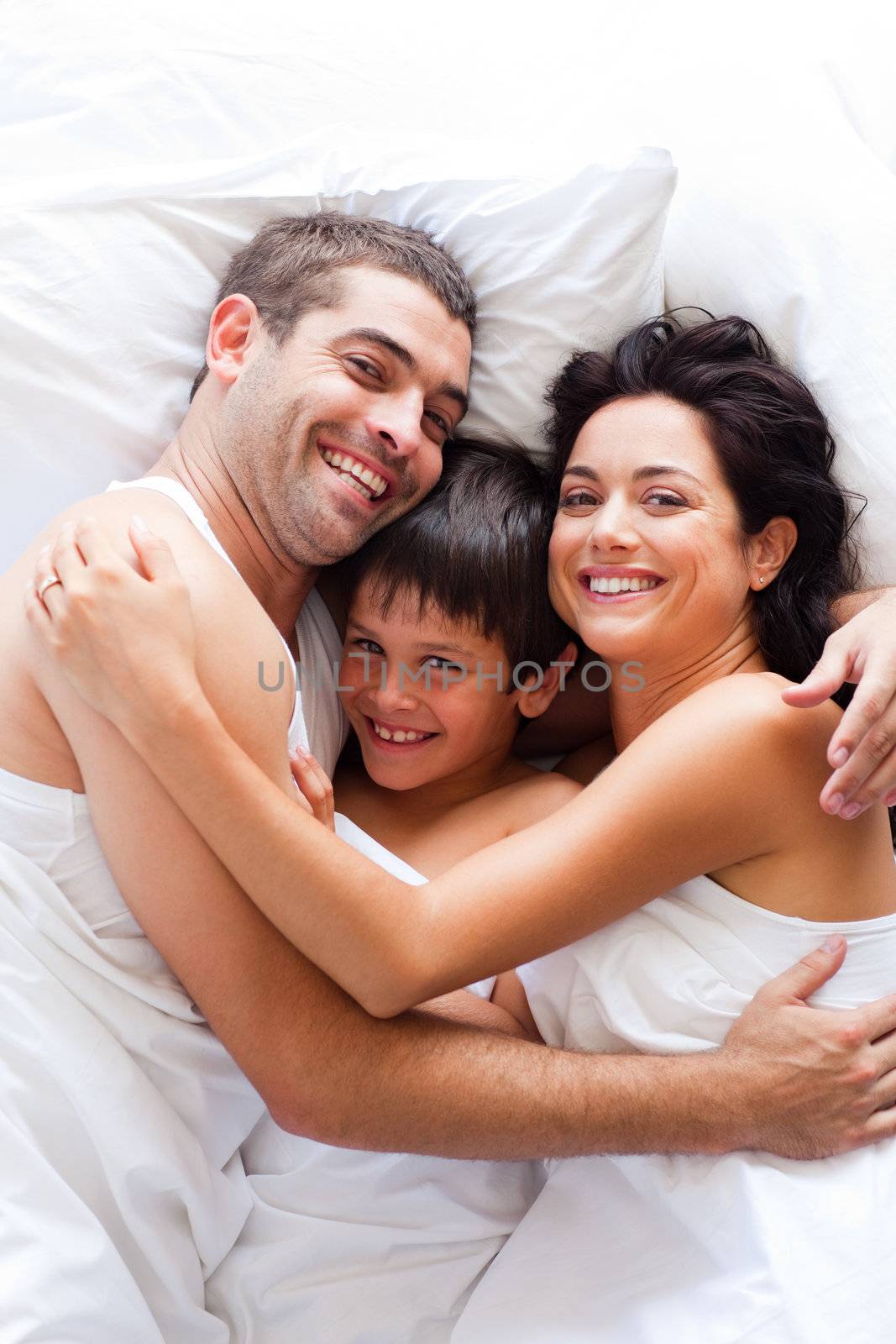 Happy young family together in bed 